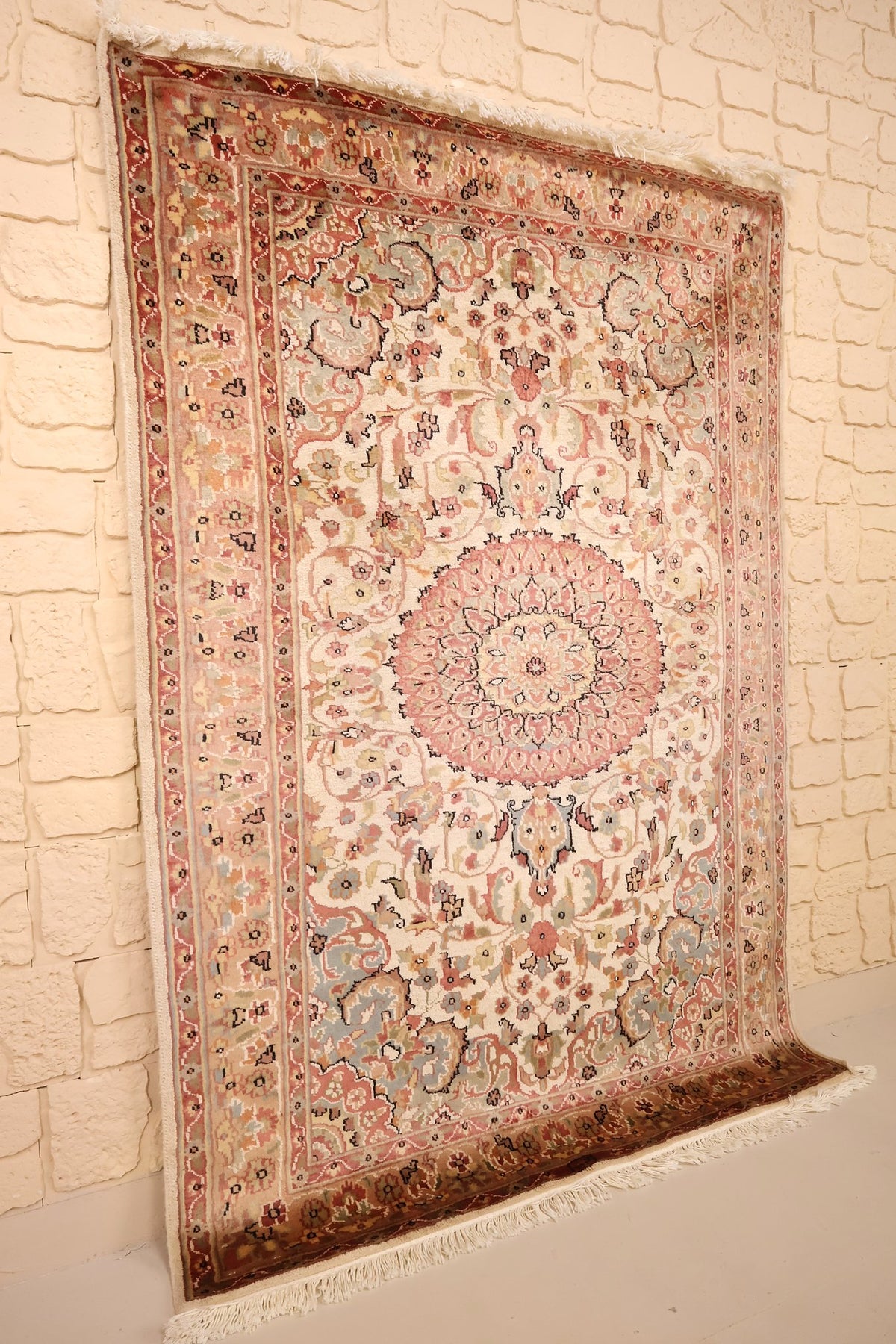Tapis PLS rectangulaire en laine, vue de biais montrant les franges crème
