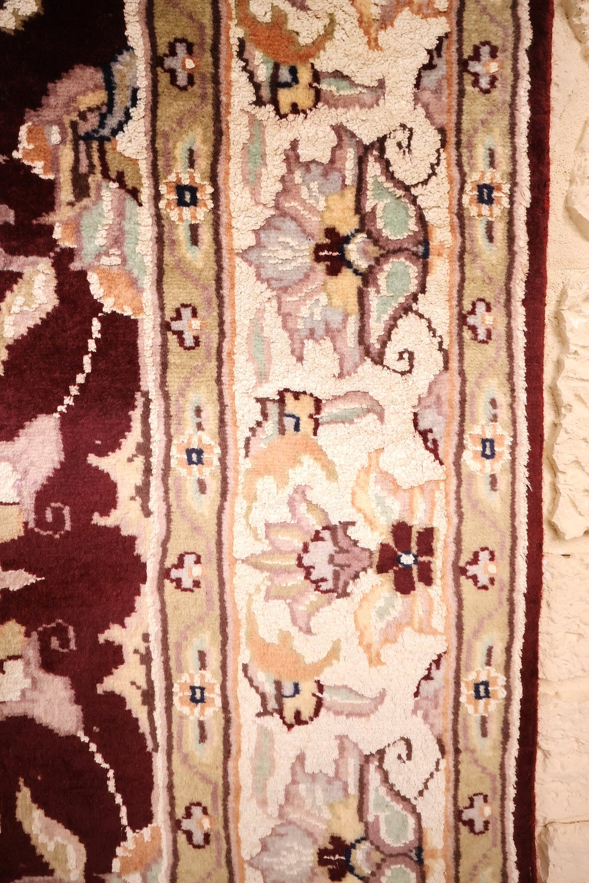 Bordure ivoire à rinceaux floraux et contre-bordures vert olive du tapis P.