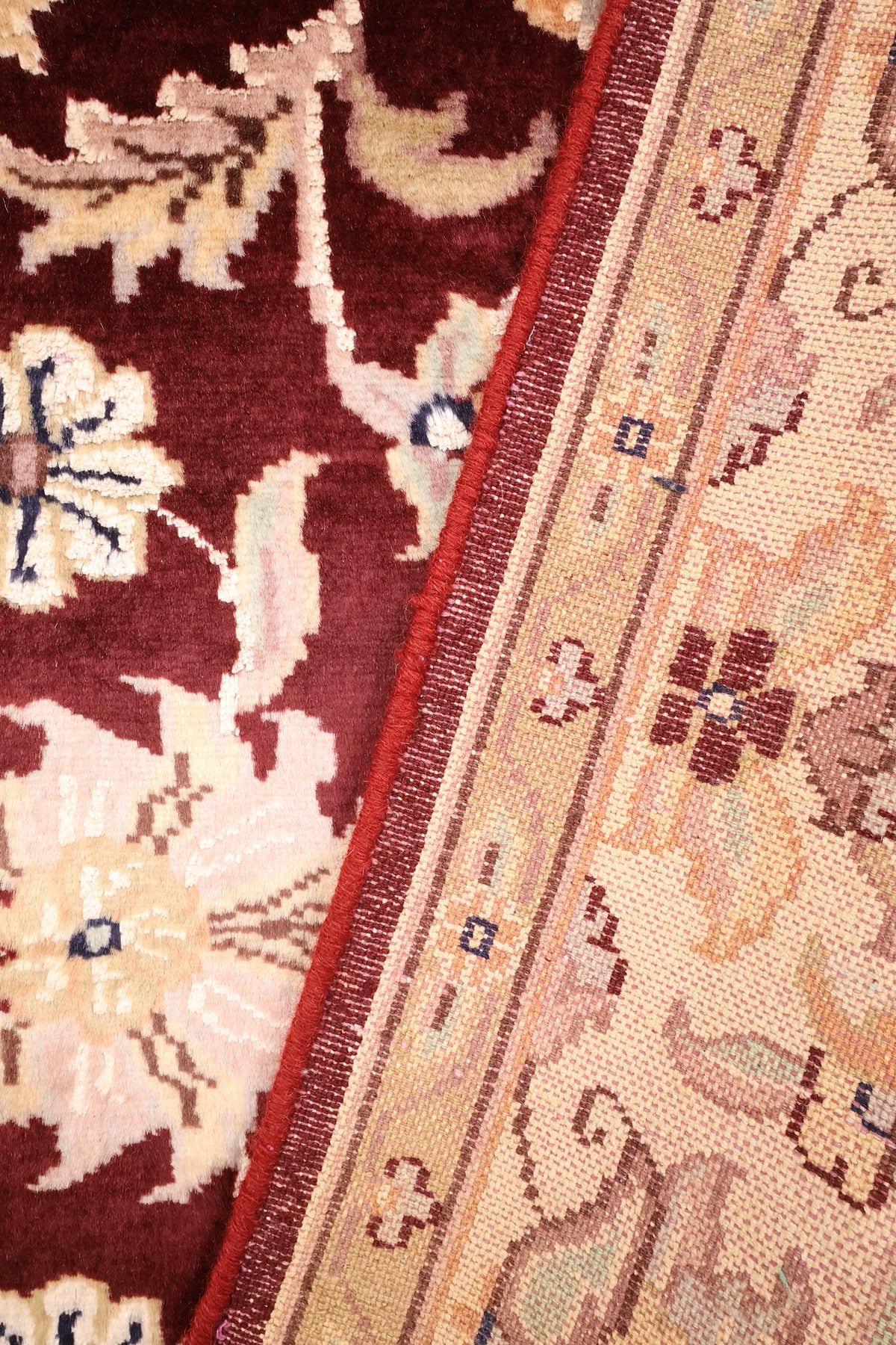 Coin replié du tapis P. rouge, envers aux nœuds serrés et fleurons ivoire