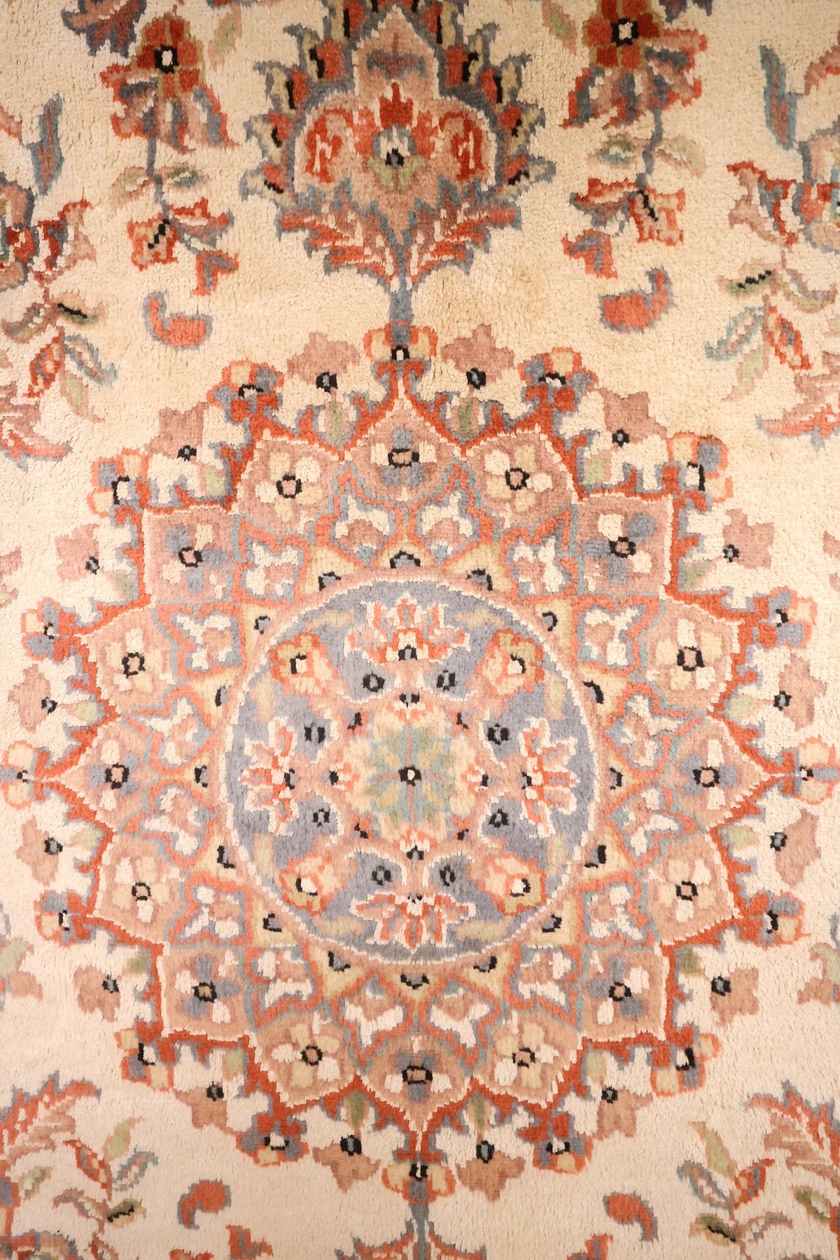 Détail du médaillon étoilé à cœur bleu-gris sur champ ivoire du tapis PLS