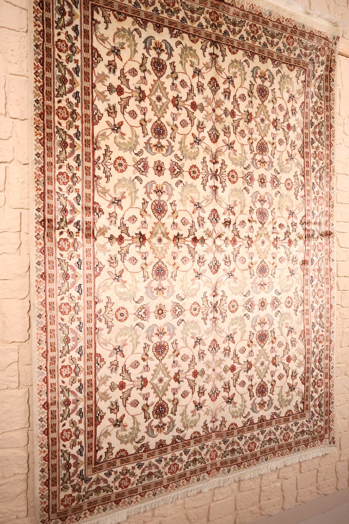 Tapis PLS rectangulaire vu de biais, palmettes rose et brun sur champ ivoire