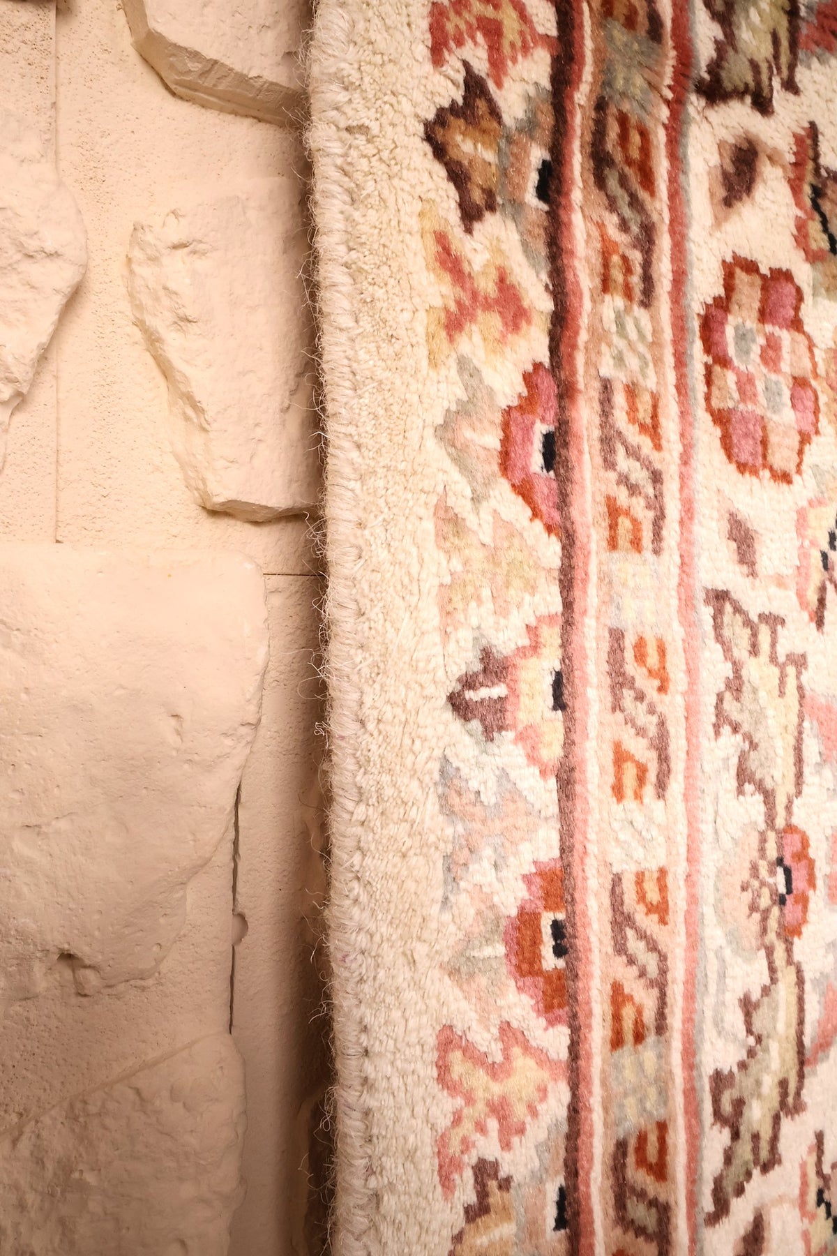 Lisière du tapis PLS beige, frange claire et contre-bordures fleuries