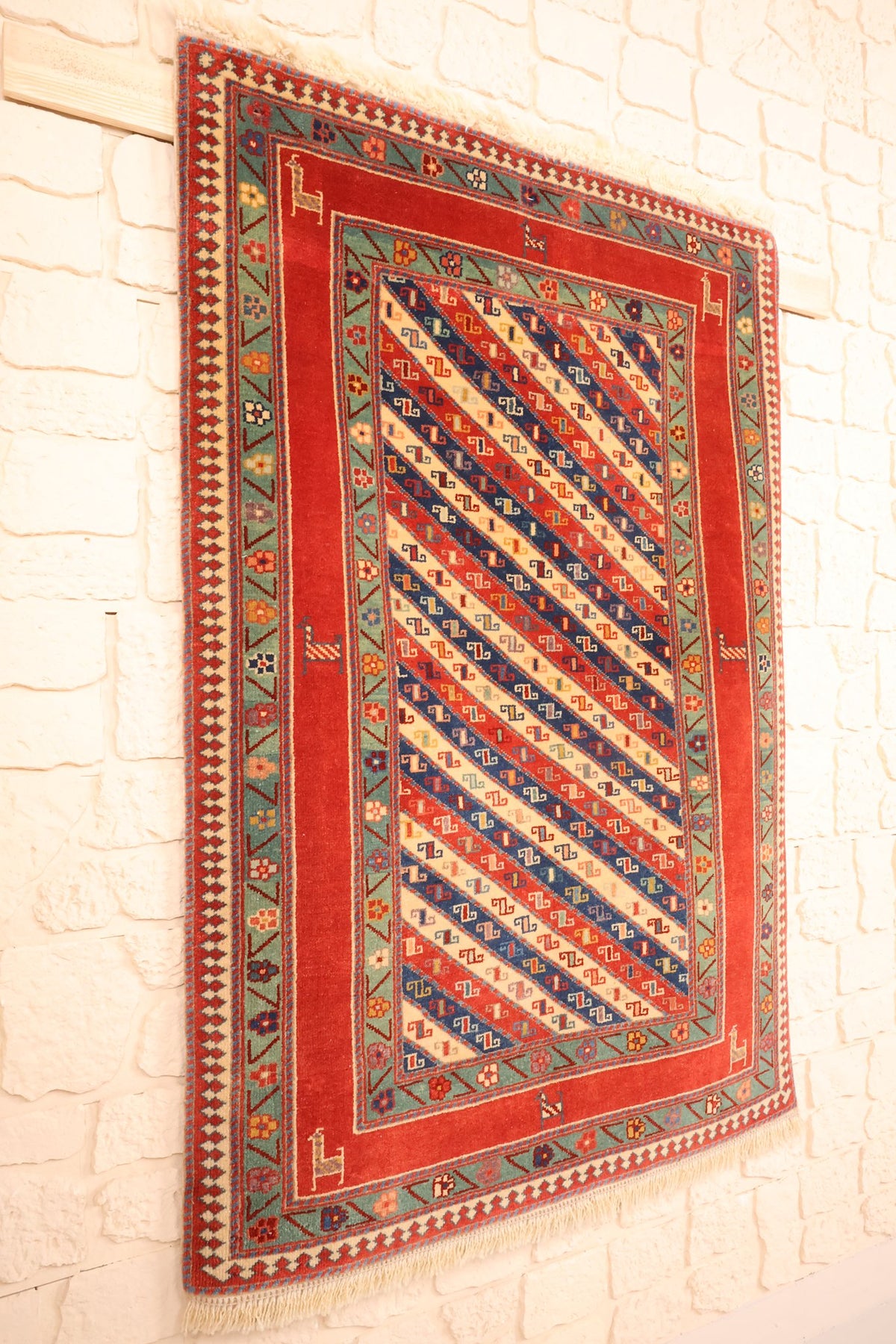 Tapis Safir en laine noué à la main, vue de biais sur le champ rouge et ses bordures