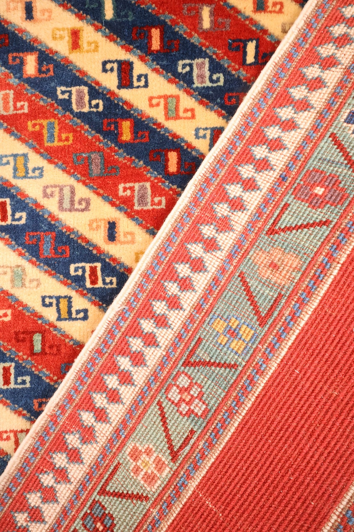 Tapis Safir replié, passage du champ rayé à la bordure vert d'eau fleurie