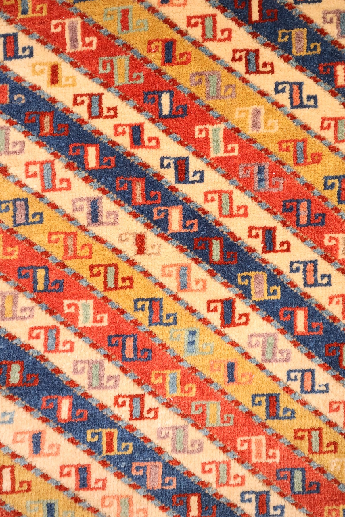 Détail du champ : bandes diagonales rouge, bleu, jaune et ivoire semées de crochets