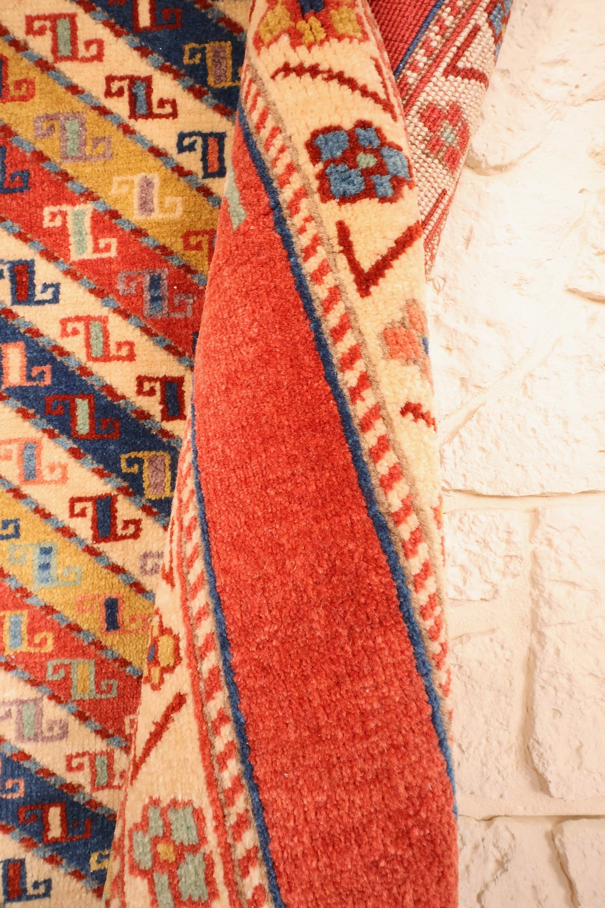 Coin replié du tapis Safir rouge, épaisseur de la laine nouée à la main