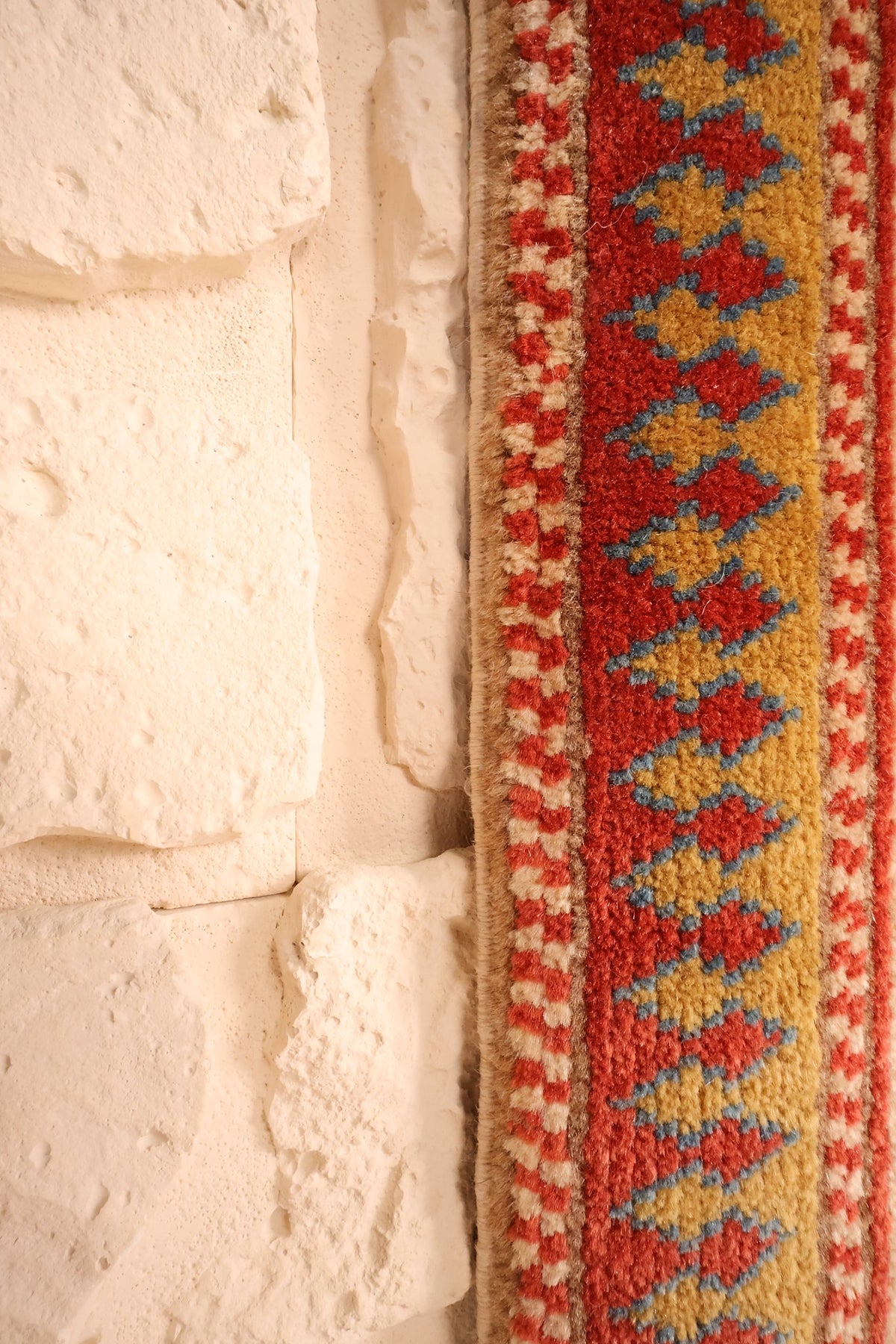 Lisière du tapis Safir, bande jaune à losanges rouges et bleus en bordure