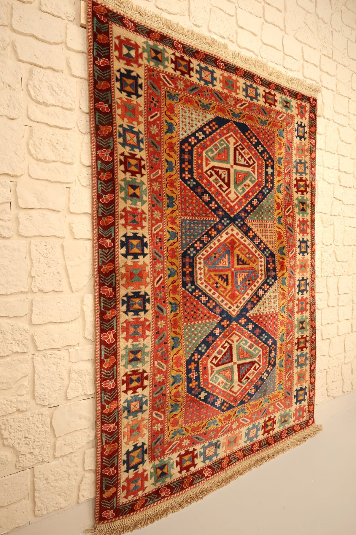 Tapis Safir rouge et bleu vu de biais, franges beiges aux deux extrémités