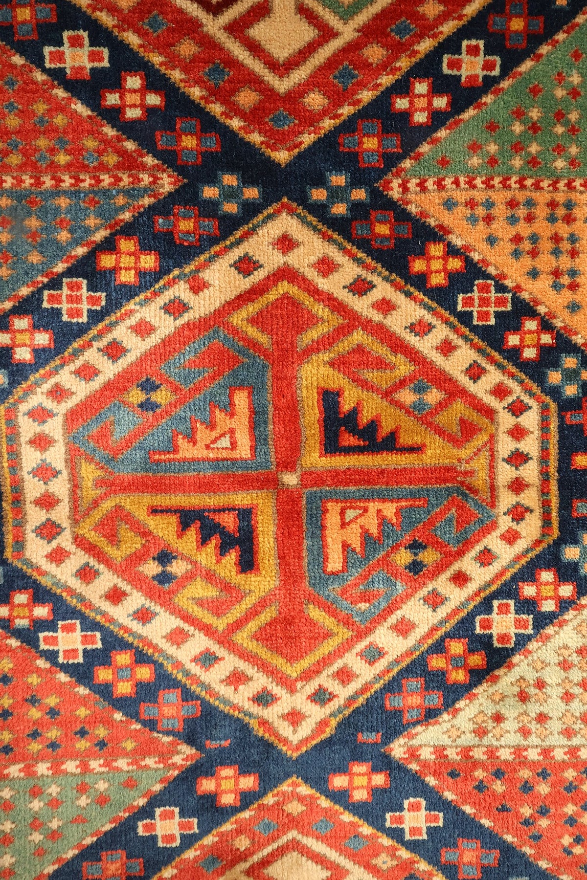 Détail d'un médaillon hexagonal à contour ivoire et motif cruciforme jaune et bleu