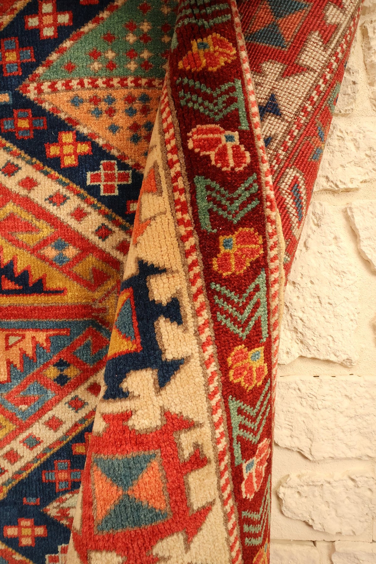 Coin retourné du tapis Safir, écoinçons orange et vert face à la bordure fleurie