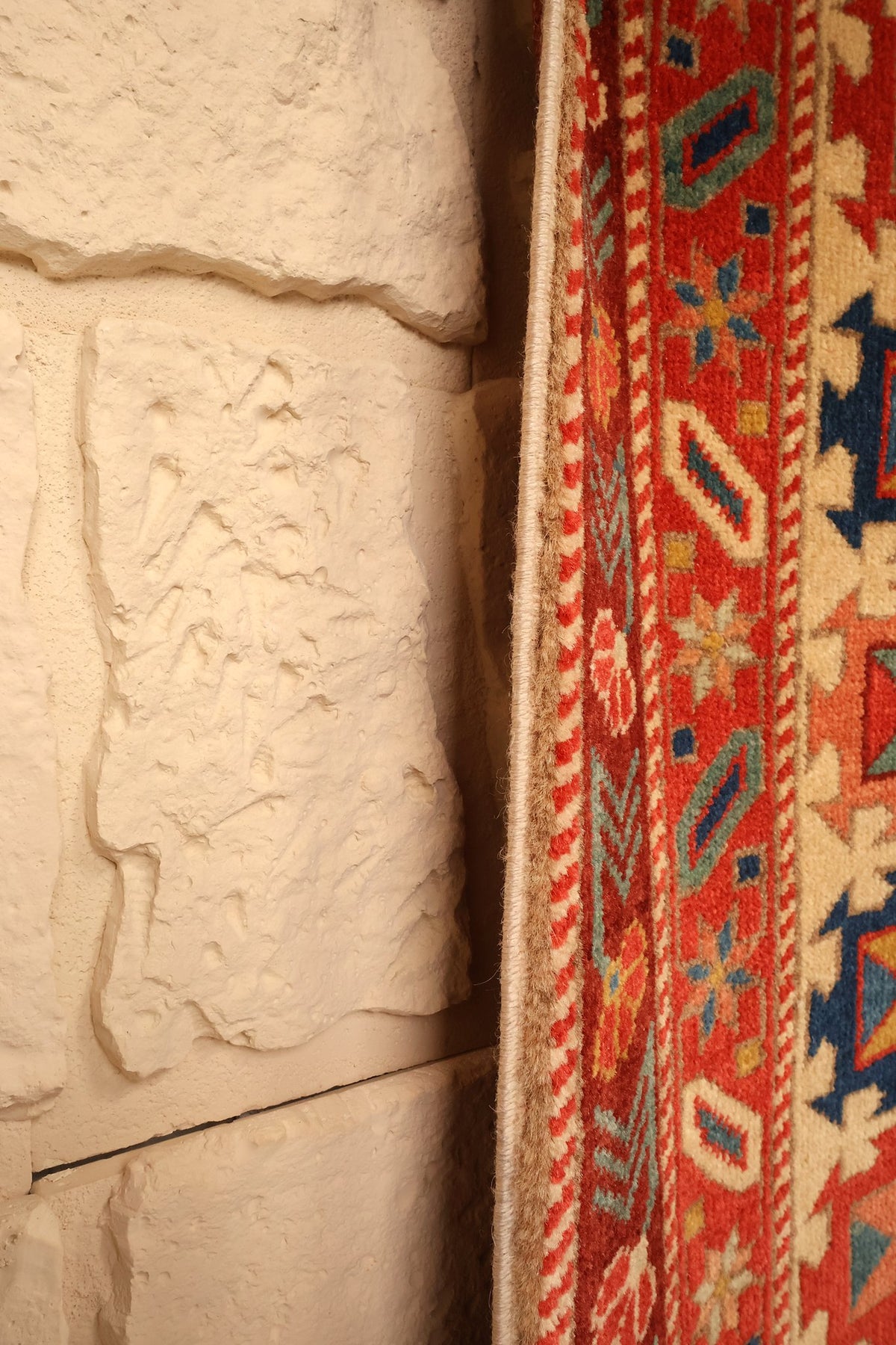 Lisière du tapis Safir beige et rouge, bordure à rosettes et cartouches ivoire