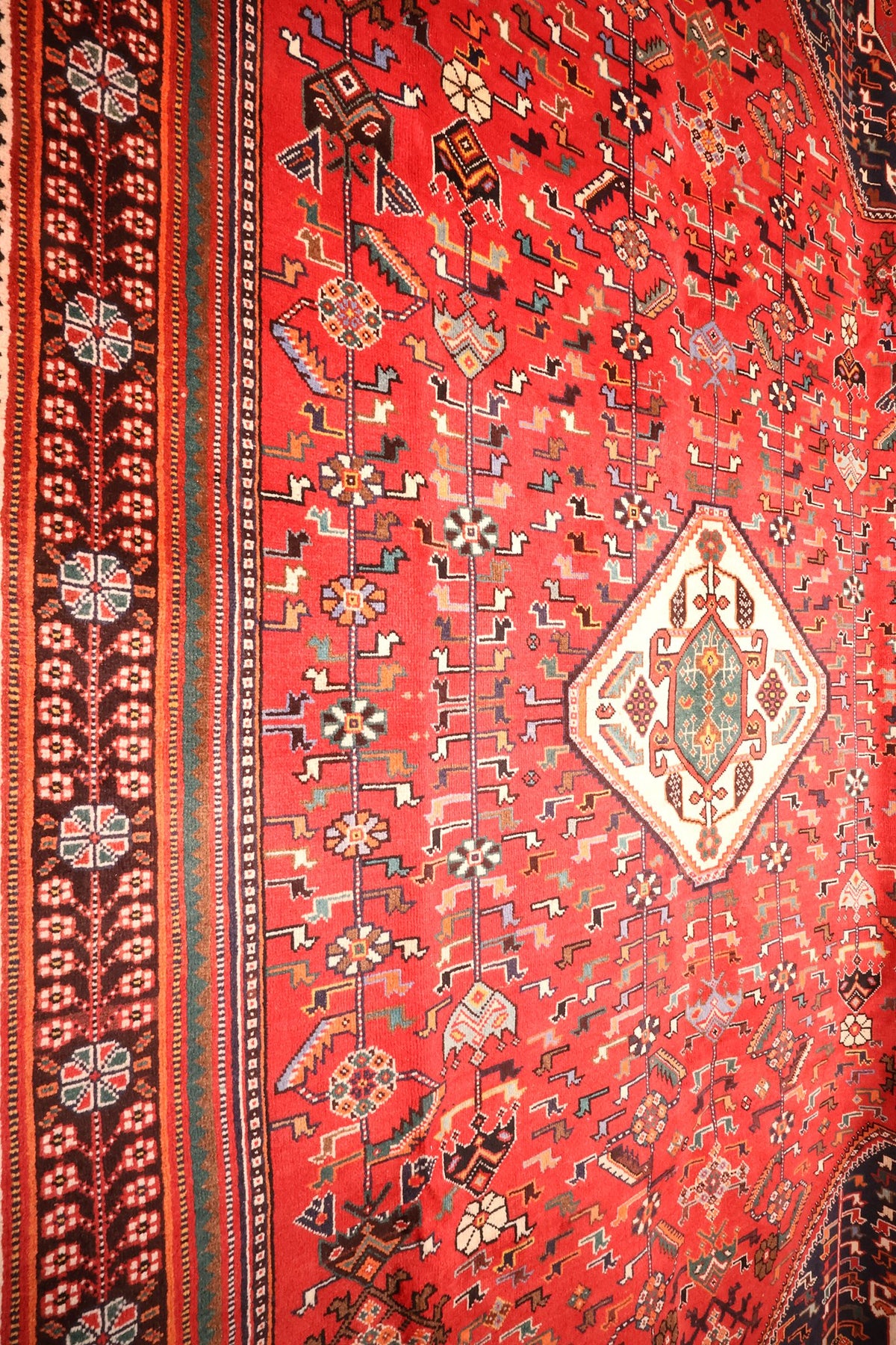 Champ rouge semé de figures animales et de rosettes, tapis Shiraz noué à la main