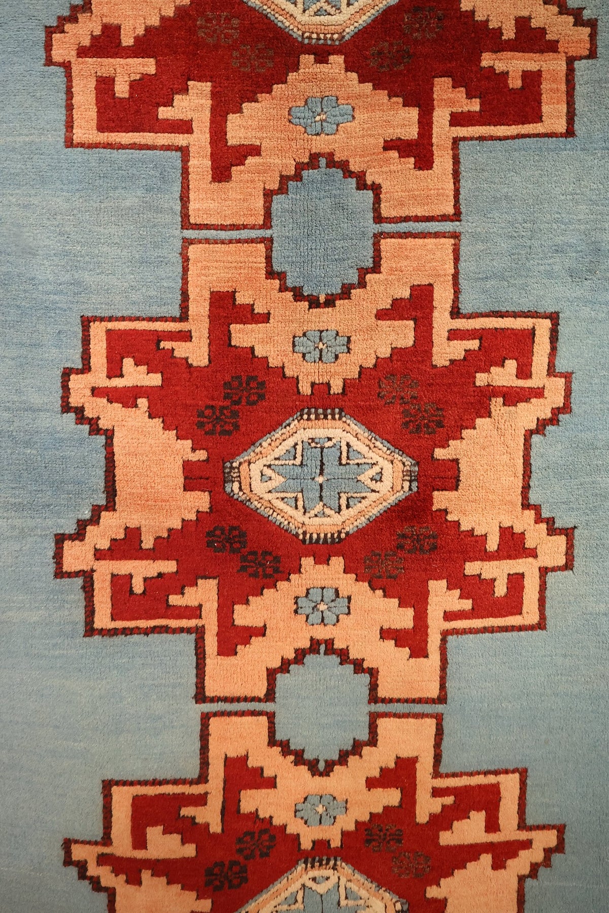 Détail des médaillons étoilés rouges et cartouches bleus sur champ bleu clair, tapis Shirvan