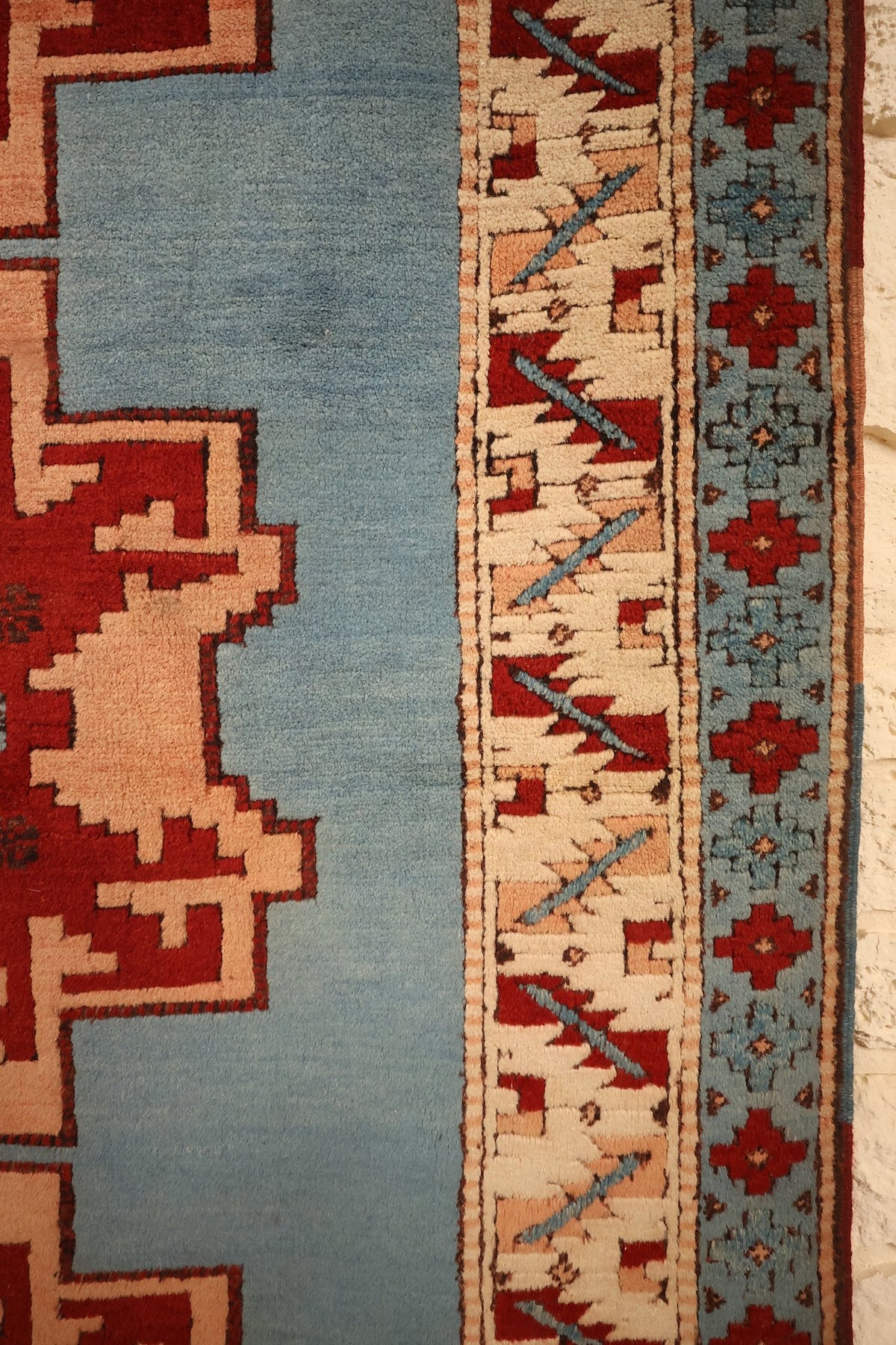 Bordure ivoire à crochets rouges et contre-bordure bleue du tapis Shirvan