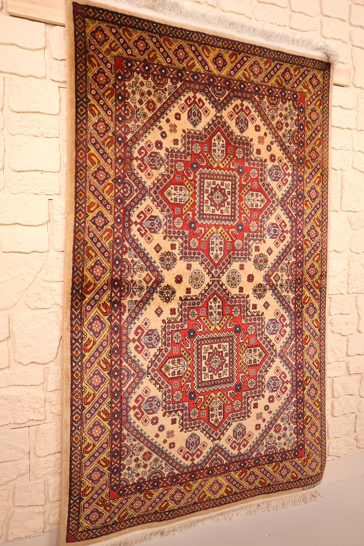 Tapis Shirvan en laine vu de biais, champ ivoire et bordure jaune à boteh