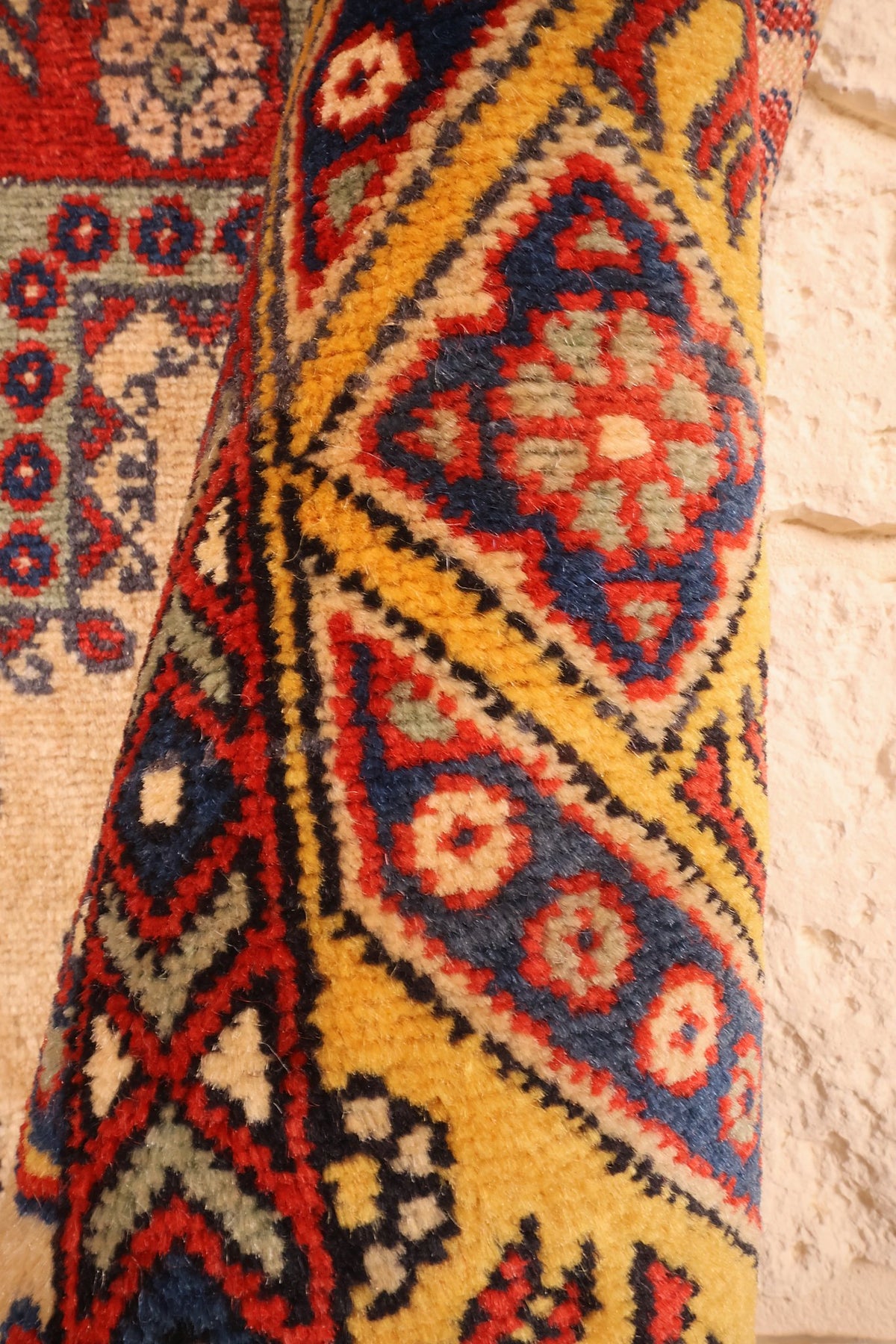 Coin replié du tapis Shirvan beige, épaisseur de laine et bordure jaune