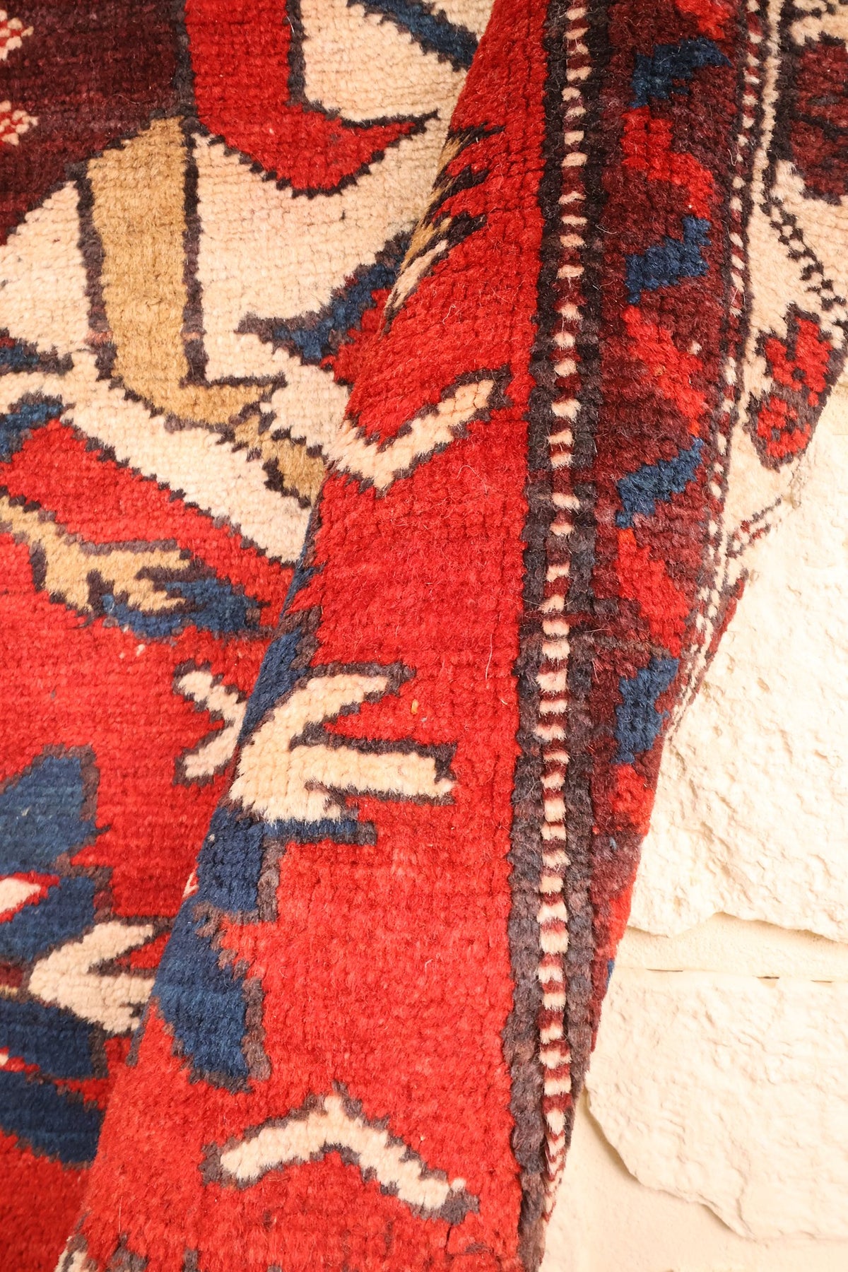 Coin relevé du tapis Shirvan 173 × 106 cm, laine rouge et motifs beige