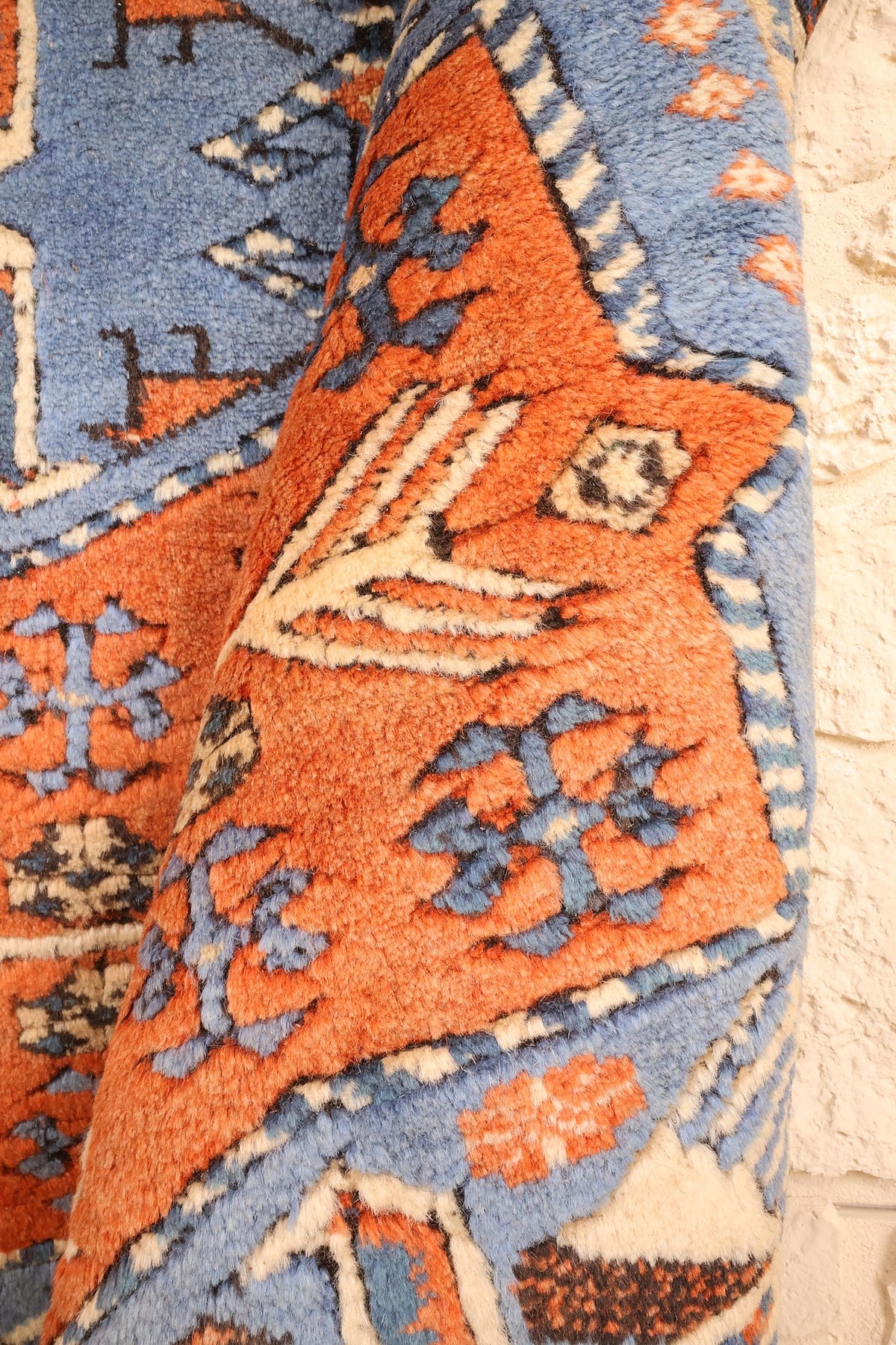 Coin replié du tapis Shirvan orange, motifs anguleux et contours ivoire