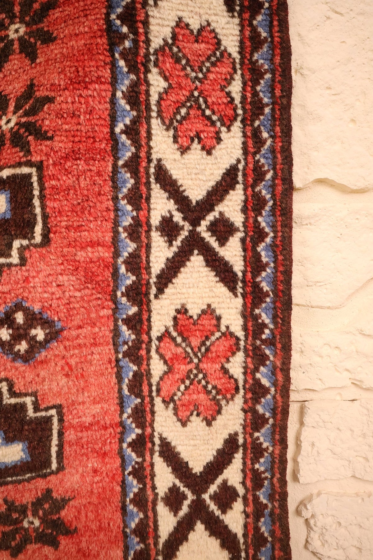 Bordure ivoire du tapis Shirvan, fleurs cruciformes roses et motifs en S bruns