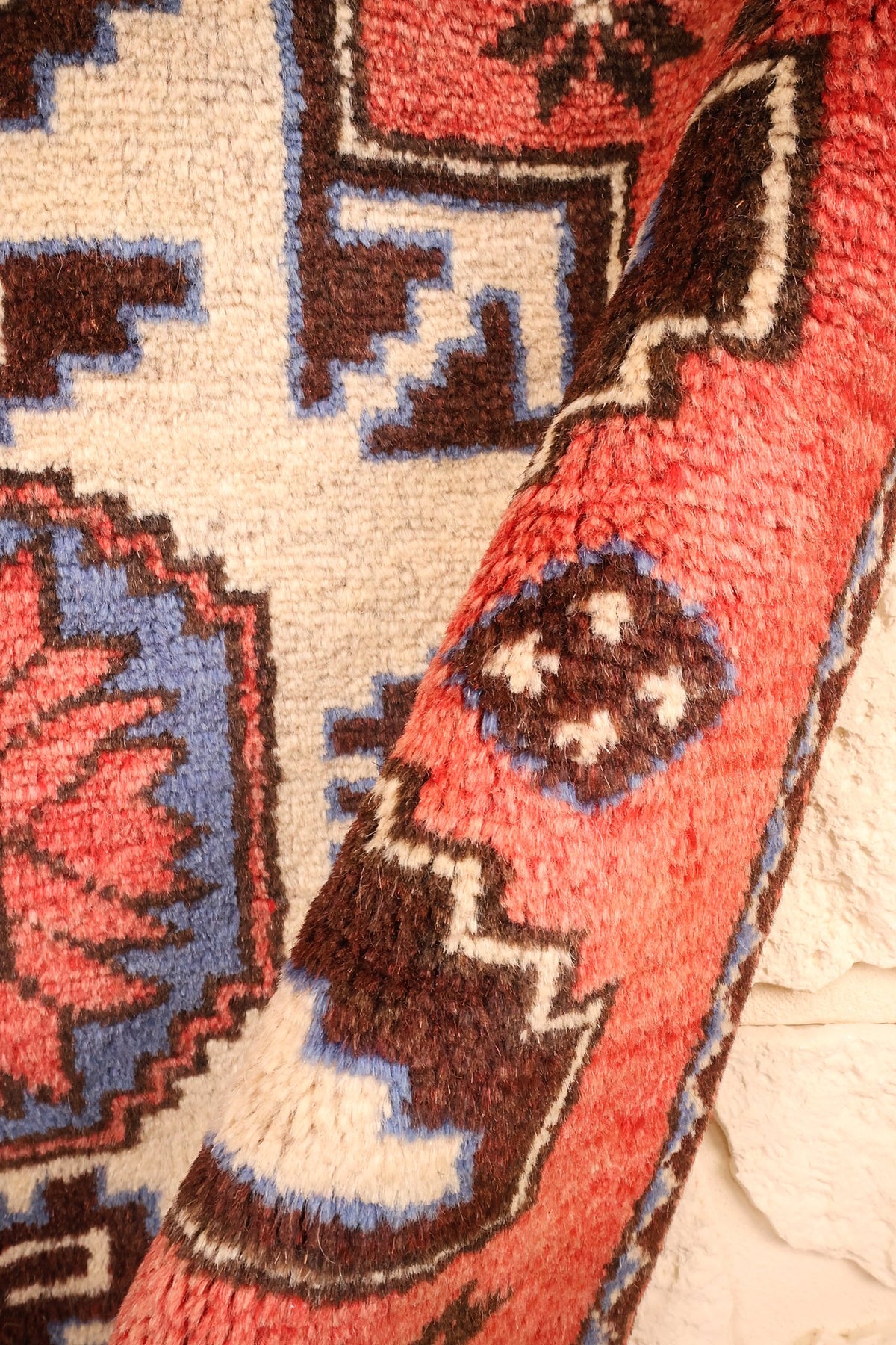 Pli du tapis Shirvan montrant losanges à gradins et étoiles brun foncé sur fond rouge