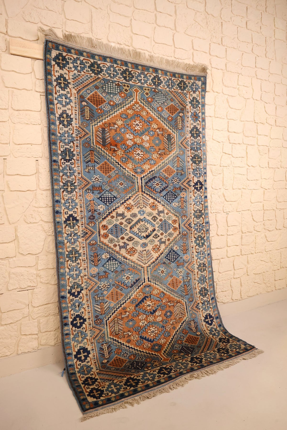 Tapis Shirvan bleu et orange en laine, vue de biais avec franges écrues