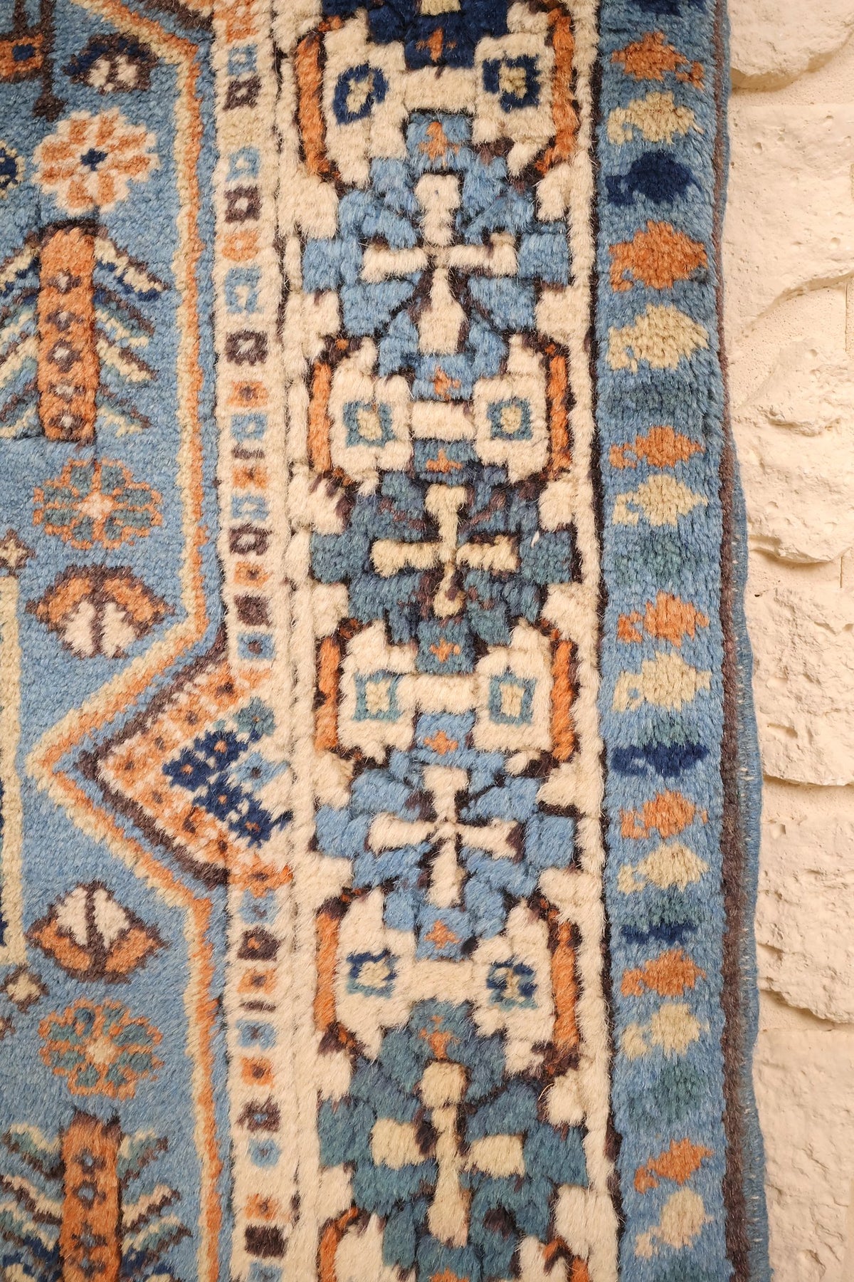 Bordure ivoire à motifs crochetés bleus et oranges du tapis Shirvan