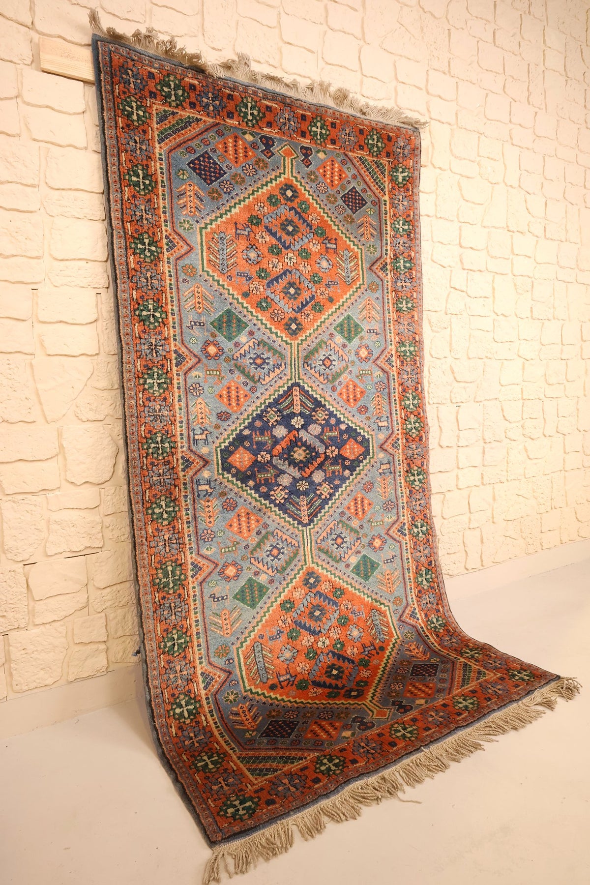 Tapis Shirvan en laine noué à la main, vue de biais sur le champ bleu et la bordure orange