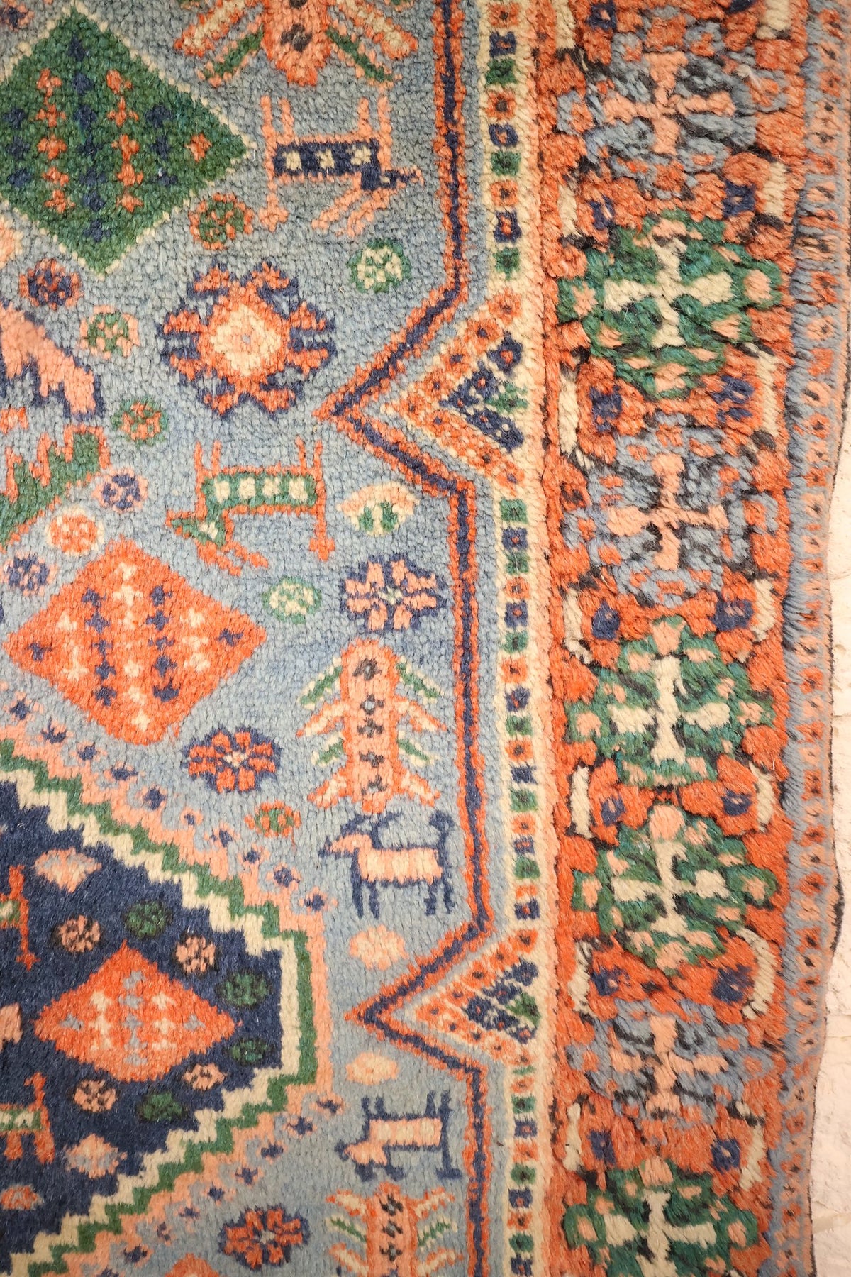 Bordure orange à motifs floraux verts et contre-bordure à damier du tapis Shirvan