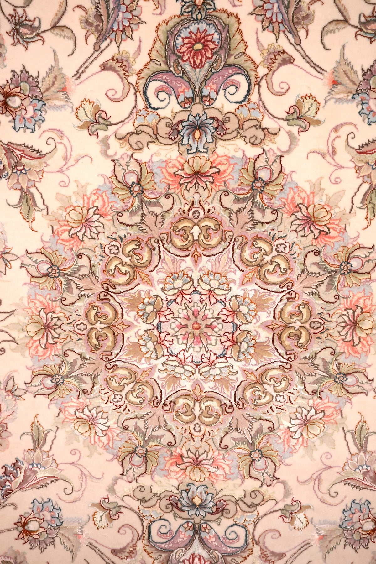 Détail du médaillon central floral rose et bleu du tapis Tabriz