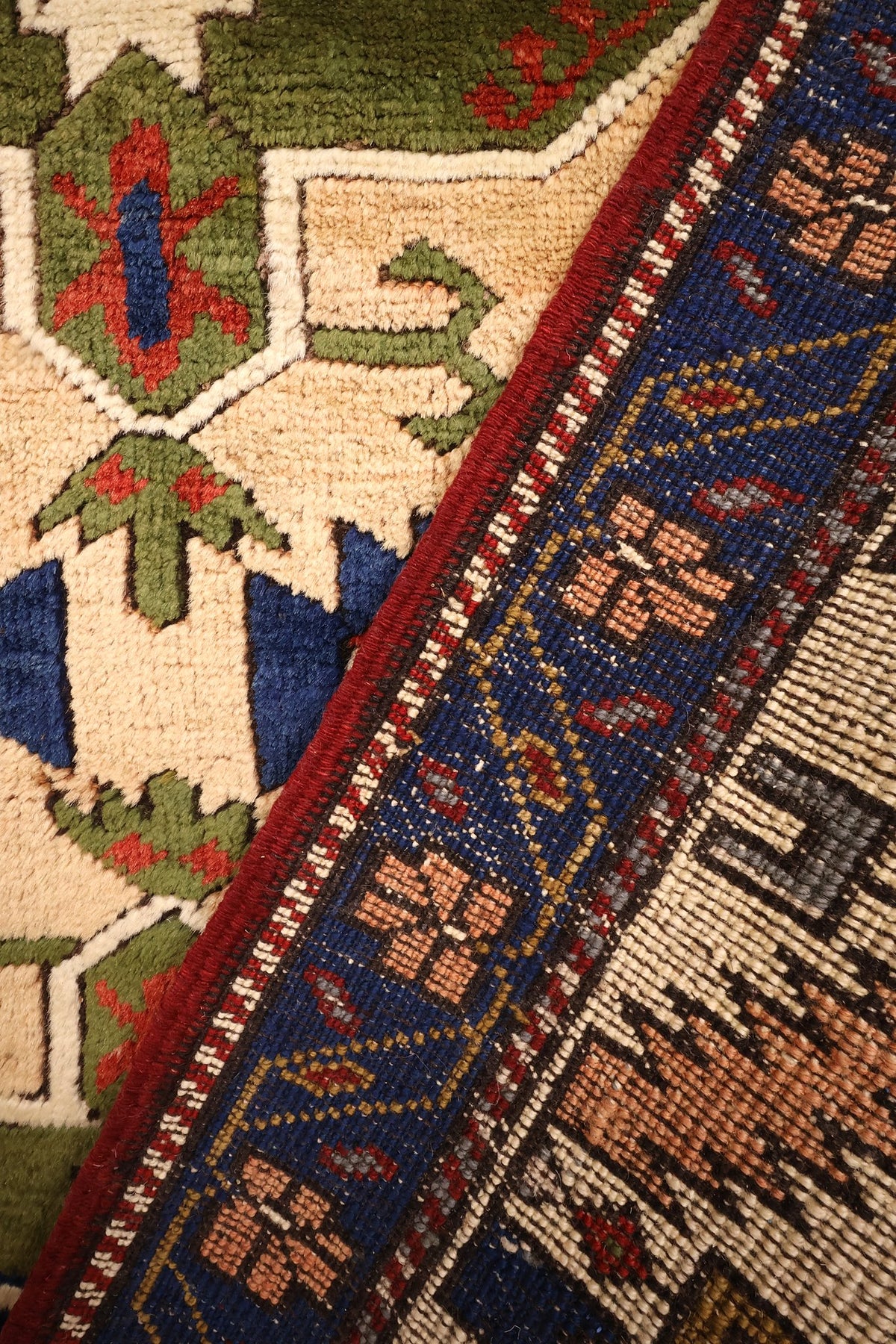 Coin replié du tapis Tachpinar, bande bleue à rosettes et champ beige