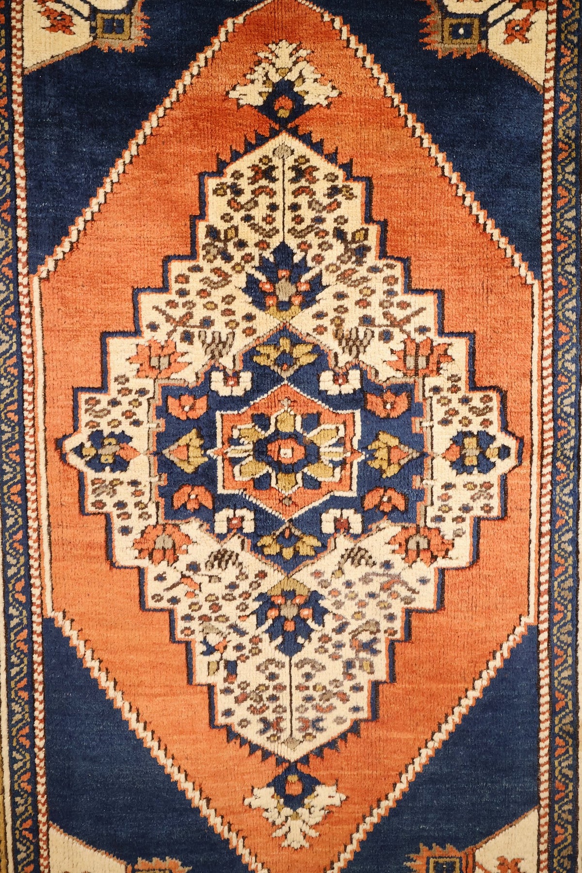 Détail du médaillon central ivoire et bleu du tapis Tachpinar orange