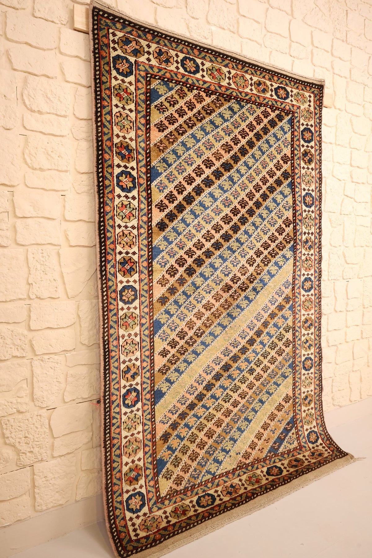Tapis Tachpinar beige et bleu vu de biais, champ rayé en diagonale sans médaillon