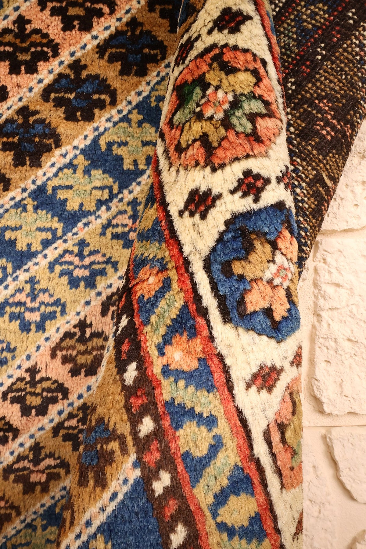 Coin replié du tapis Tachpinar, contre-bordures à rinceaux bleus et envers sombre