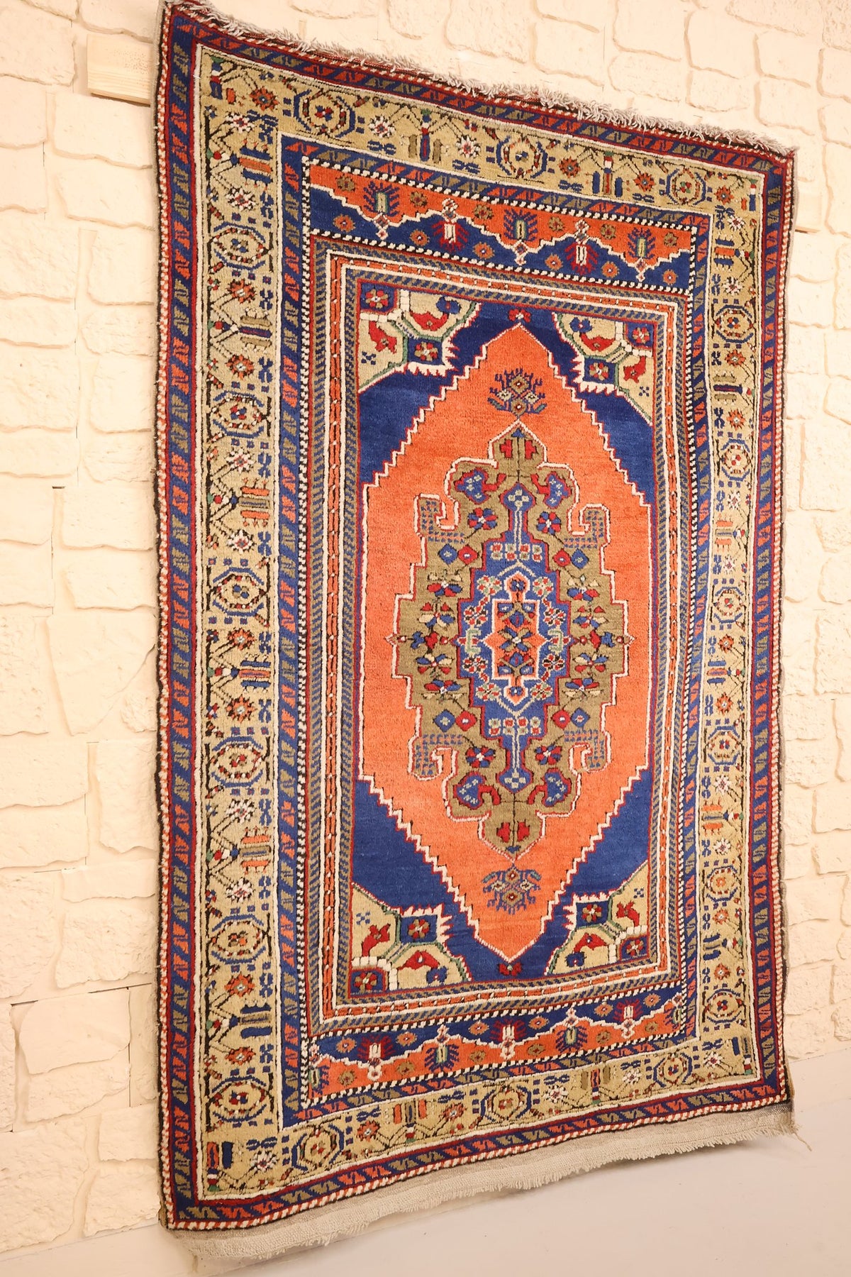 Tapis Tachpinar orange vu de biais, médaillon losangé et écoinçons bleus