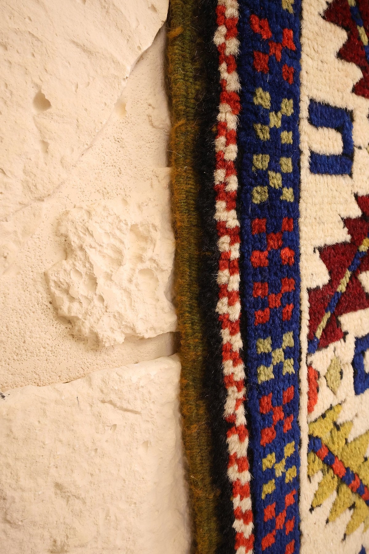 Lisière du tapis Tachpinar le long des contre-bordures bleues semées de motifs rouges et verts