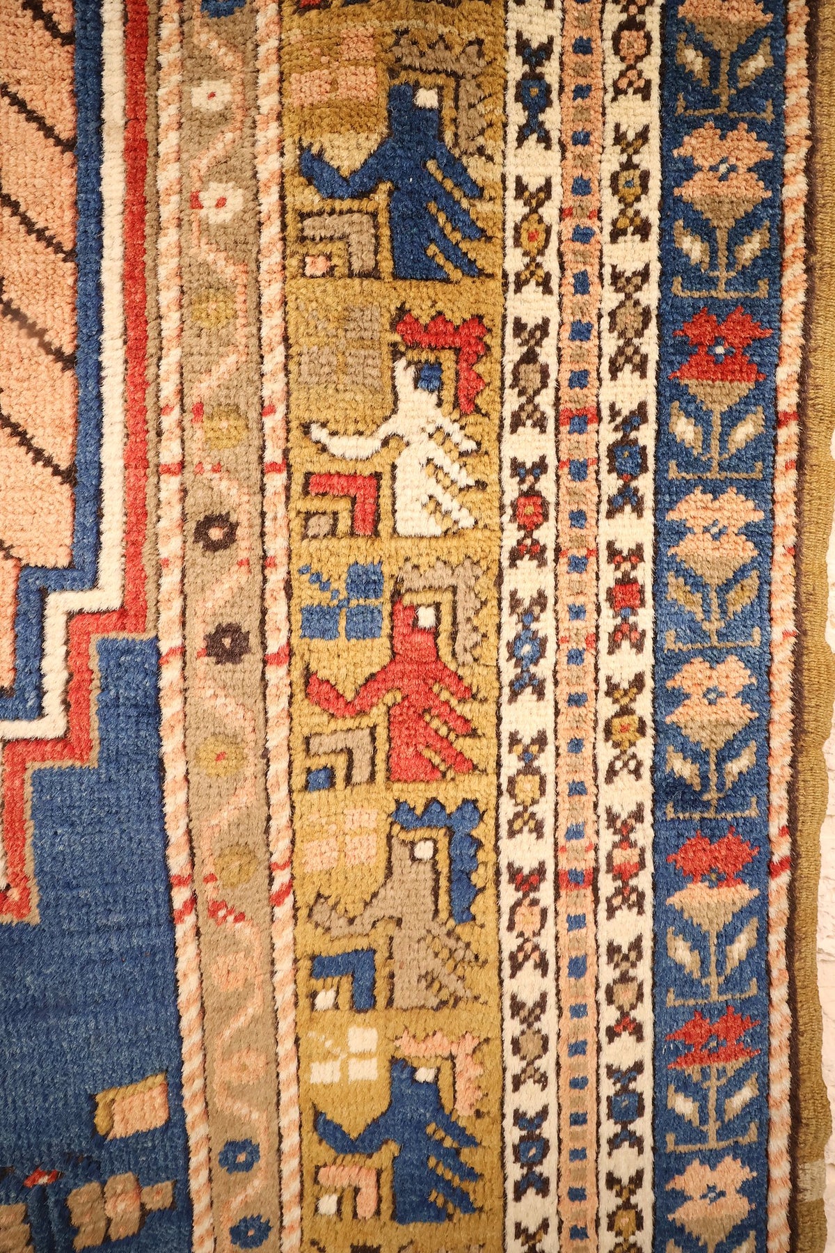 Bordure ocre à figures humaines stylisées et bande bleue fleurie du Tachpinar