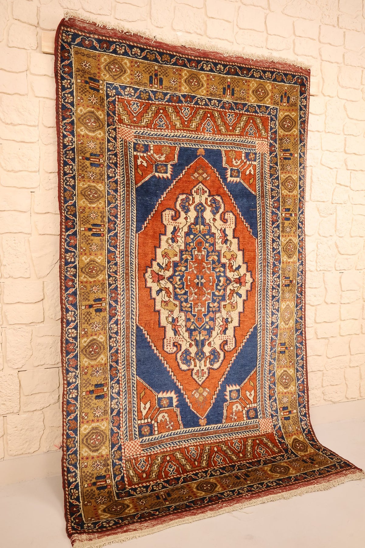 Tapis Tachpinar rectangulaire orange et bleu, vue de biais avec sa bordure jaune moutarde