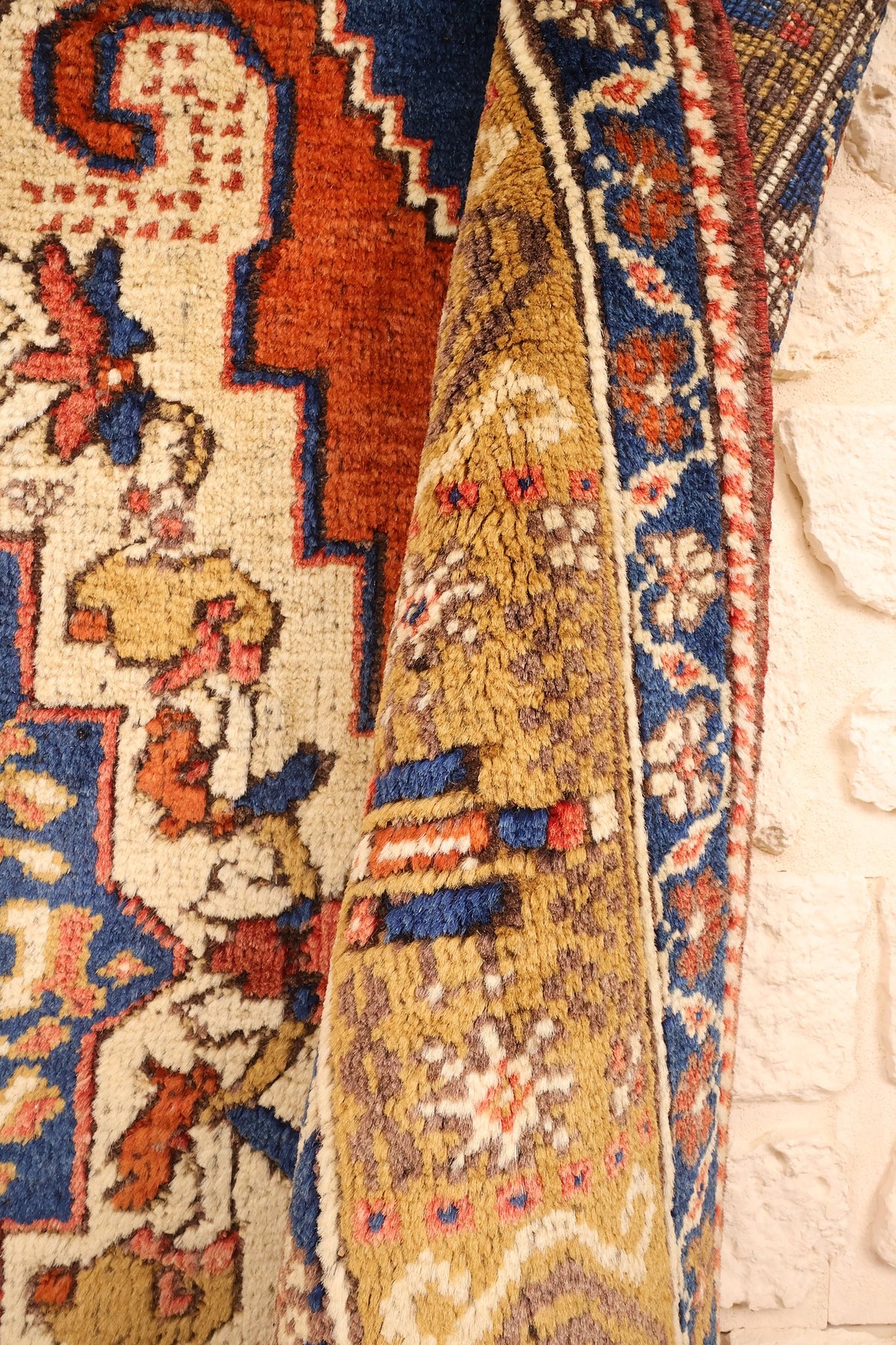 Tapis Tachpinar orange replié, épaisseur et galon ivoire en torsade de la bordure