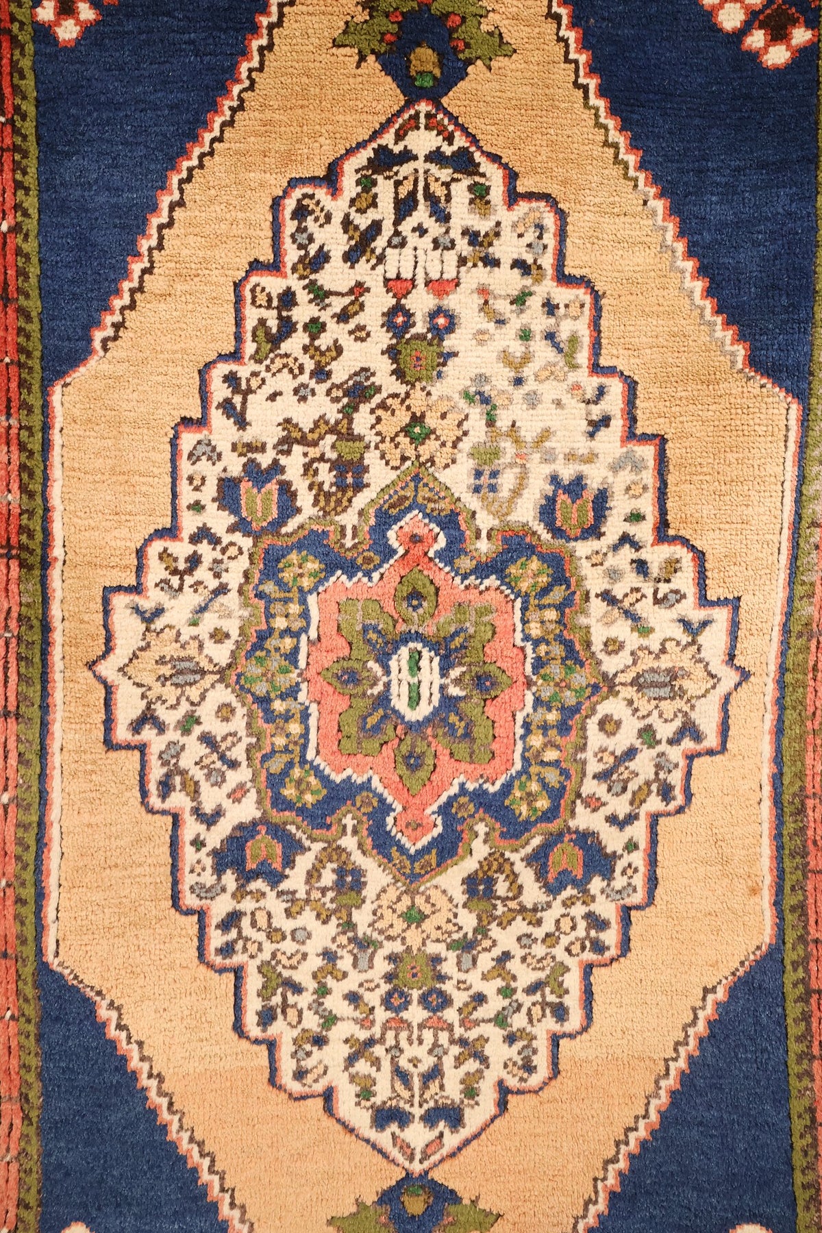 Détail du médaillon beige à cartouche ivoire et cœur rose et vert sur champ bleu
