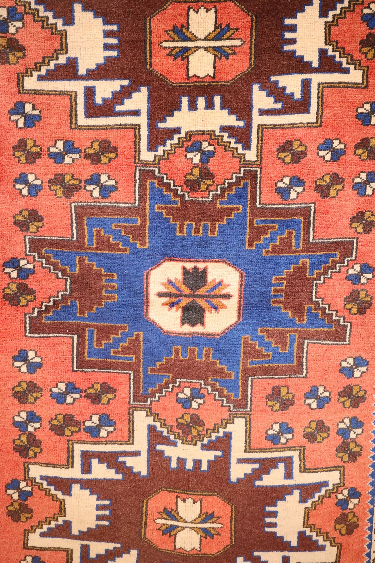 Détail de l'étoile centrale bleue et des rosettes semées sur le champ orange