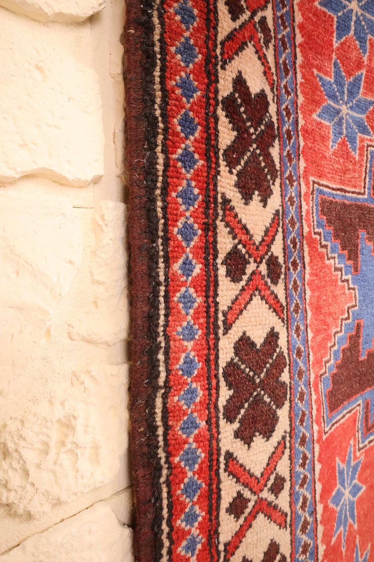 Lisière brune du tapis Yagci Bedir le long de la contre-bordure rouge et bleue