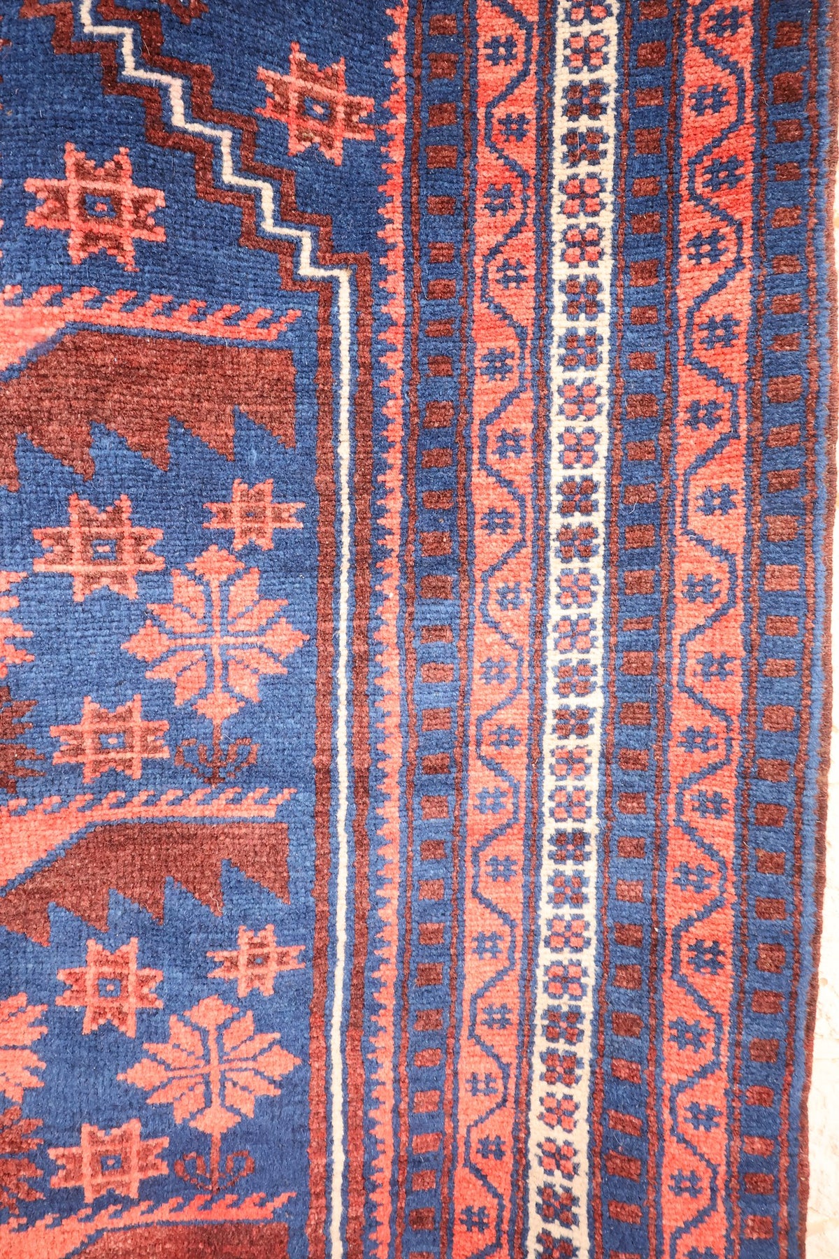 Bordures du tapis Yagci Bedir, bande ivoire fleurie et galons à vaguelettes rouge brique