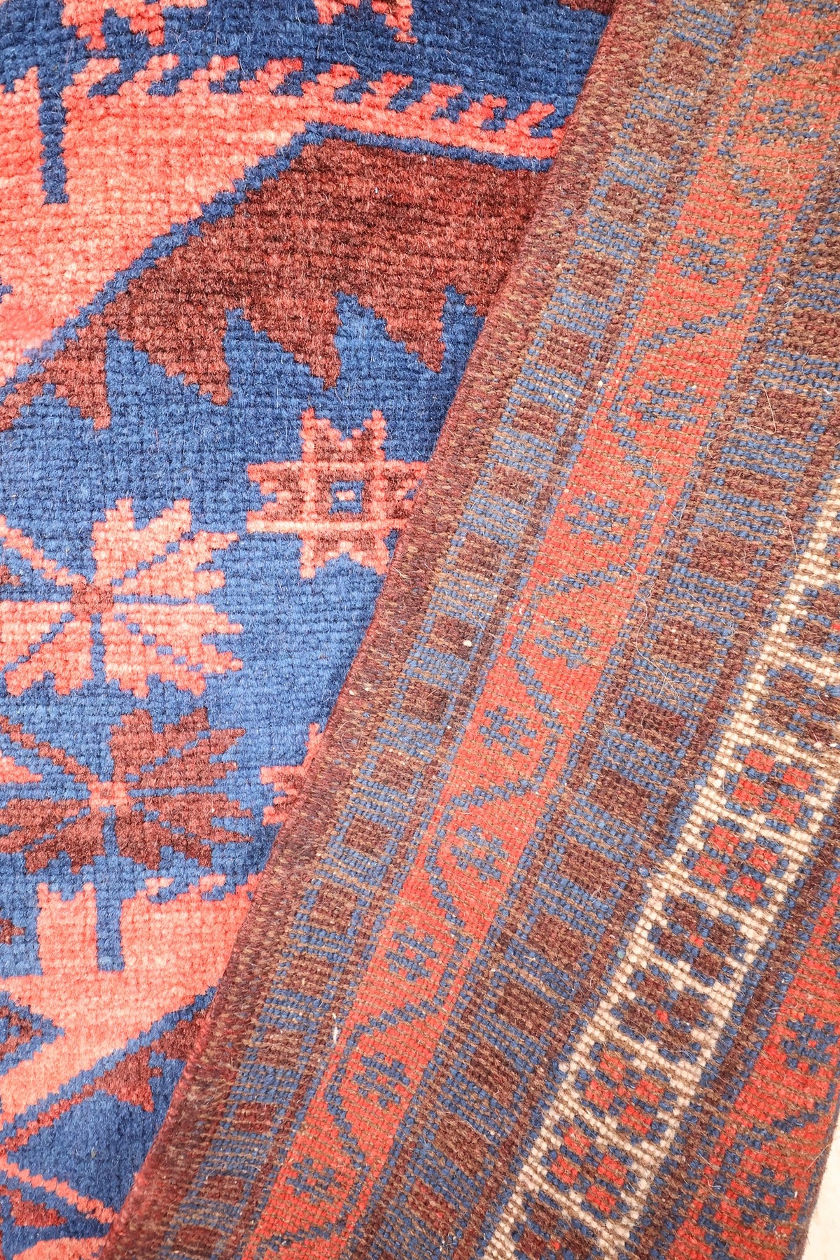 Coin replié du tapis Yagci Bedir, panneau triangulaire brun et galons de l'encadrement