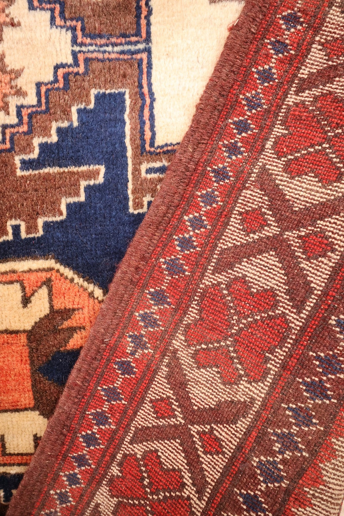 Coin replié du tapis Yagci Bedir, envers et nœuds visibles près de la bordure brune