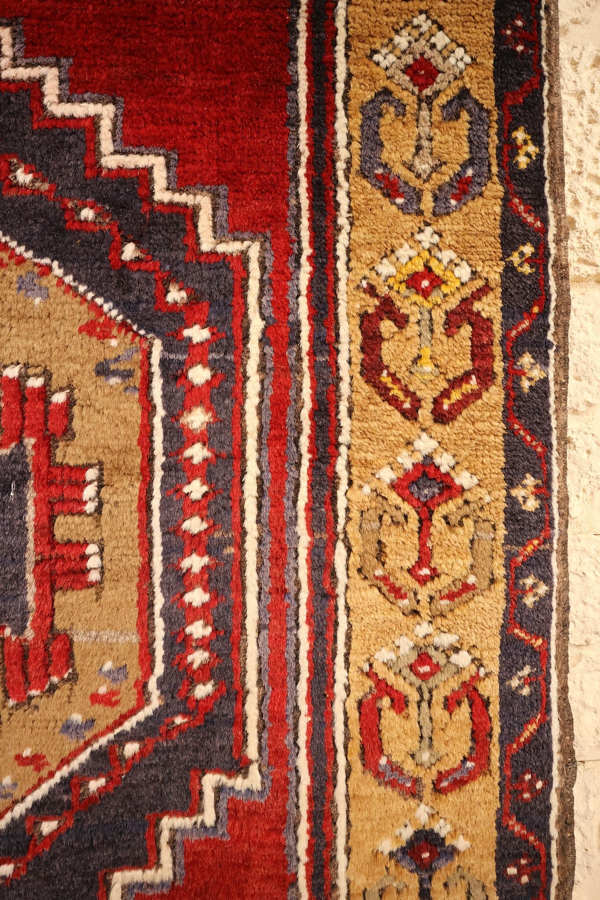 Bordure beige doré à motifs crochetés rouges et bleus du tapis Yahyali