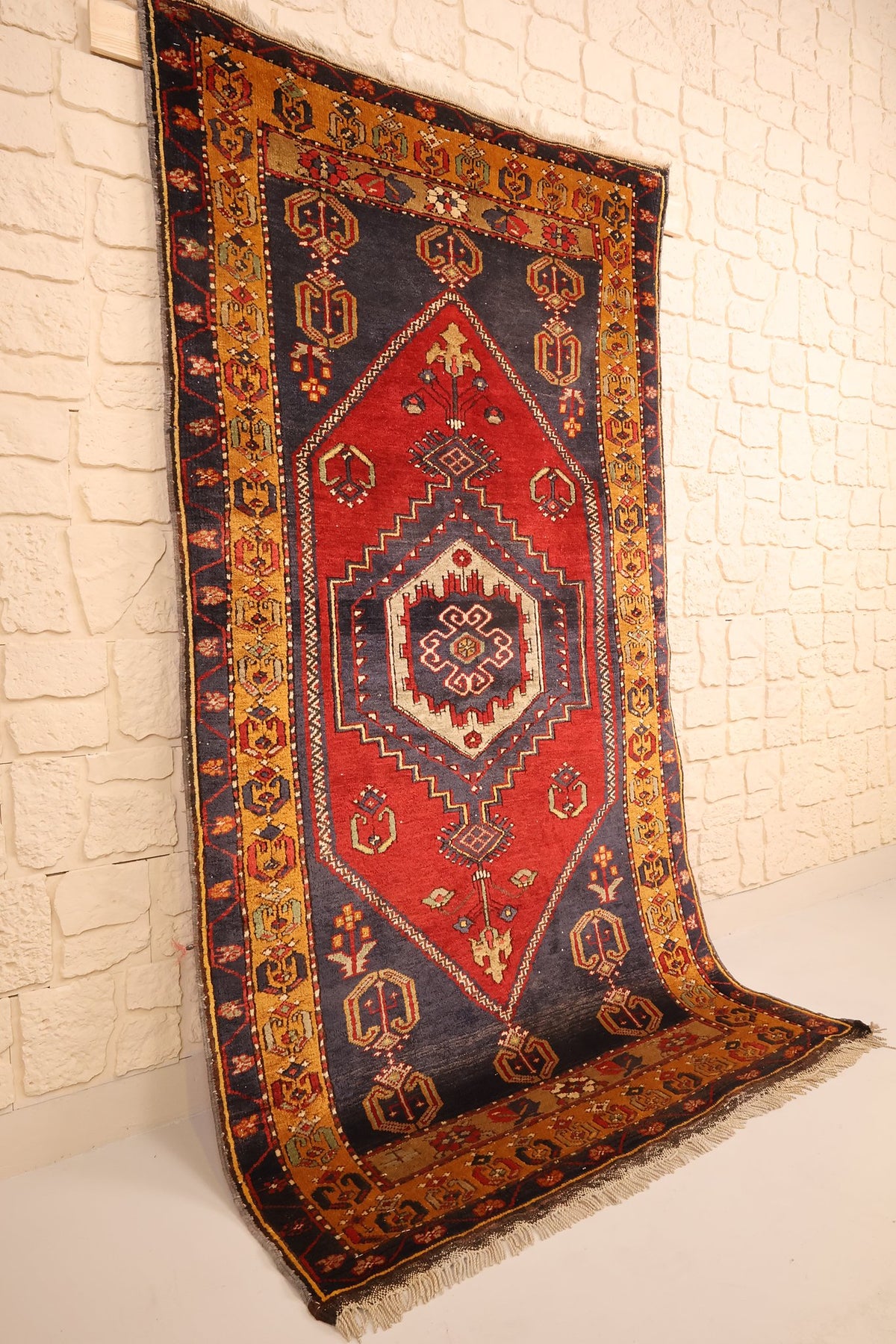 Tapis Yahyali rectangulaire rouge et bleu, vue de biais montrant la bordure jaune-orange