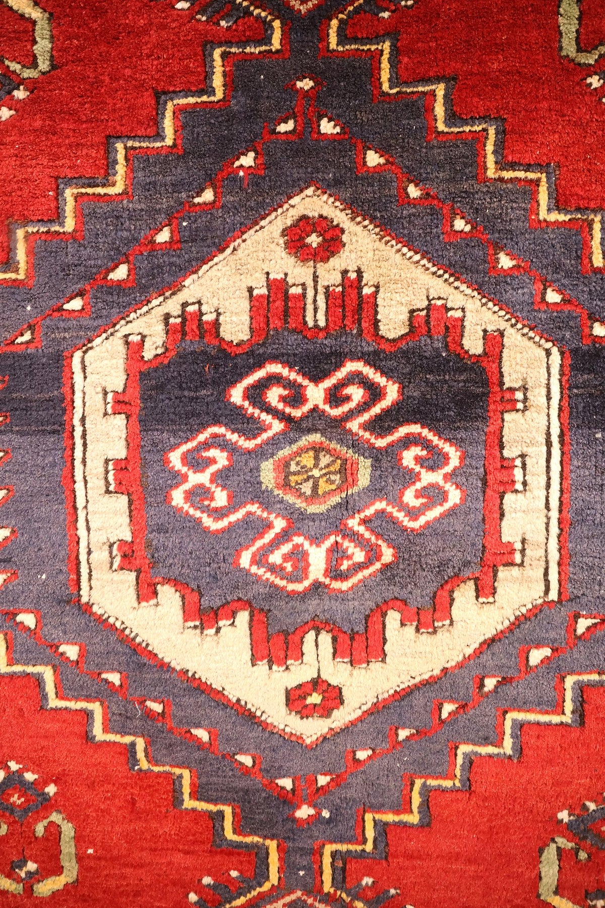 Détail du cartouche ivoire et du motif crocheté rouge au centre du tapis Yahyali