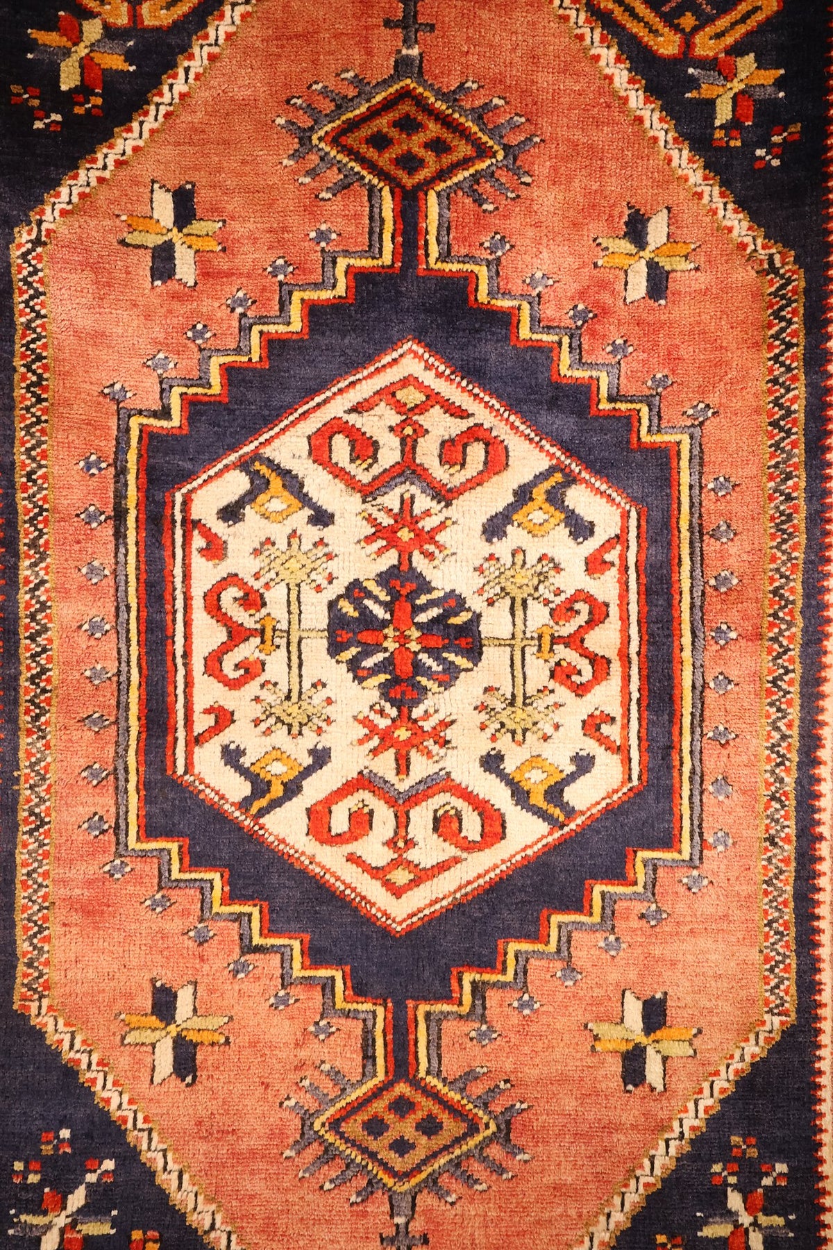 Détail du médaillon rose saumon et du cartouche ivoire à crochets rouges