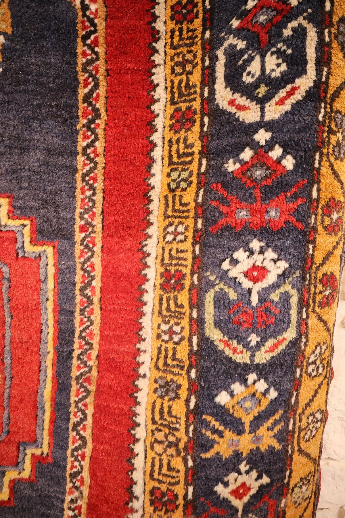 Bordure bleu nuit à fleurs crème et bandes jaune safran à méandres, tapis Yahyali