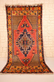 Tapis Yahyali rouge 220 × 113 cm, vue d'ensemble avec médaillon losangé bleu nuit
